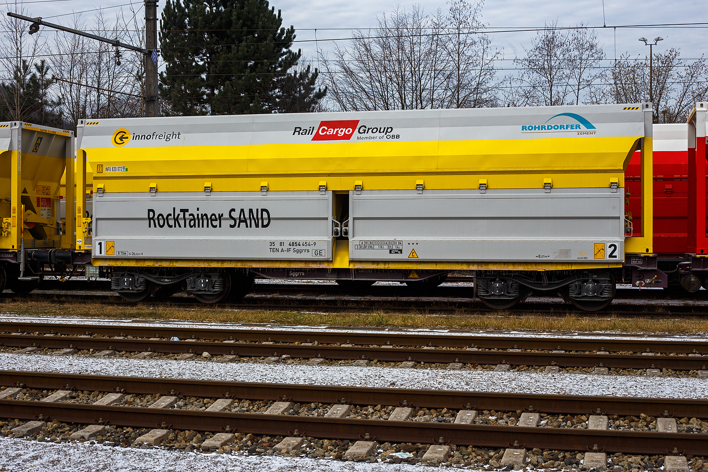 Detailbild des 2 x 4-achsigen Flachwagen in Sonderbauart (Doppelwagen) bzw. ein 8-achsiger Containertragwagen, 35 81 4854 454-9 A-IF, der Gattung Sggrrs
80 ft, der �sterreichischen INNOFREIGHT bzw, Rail Cargo Austria, abgestellt am 14 Januar 2025 beim Bahnhof Gmunden bzw. beim Zementwerk Hatschek in Gmunden der Rohrdorfer Zement GmbH. Die achtachsige Wageneinheit (80ft Sggrrs IW) ist f�r den Transport von Ladegut mit Ladegestellen geeignet, hier in der Variante J - RockTainer SAND mit einer ISO-L�nge von 40‘

