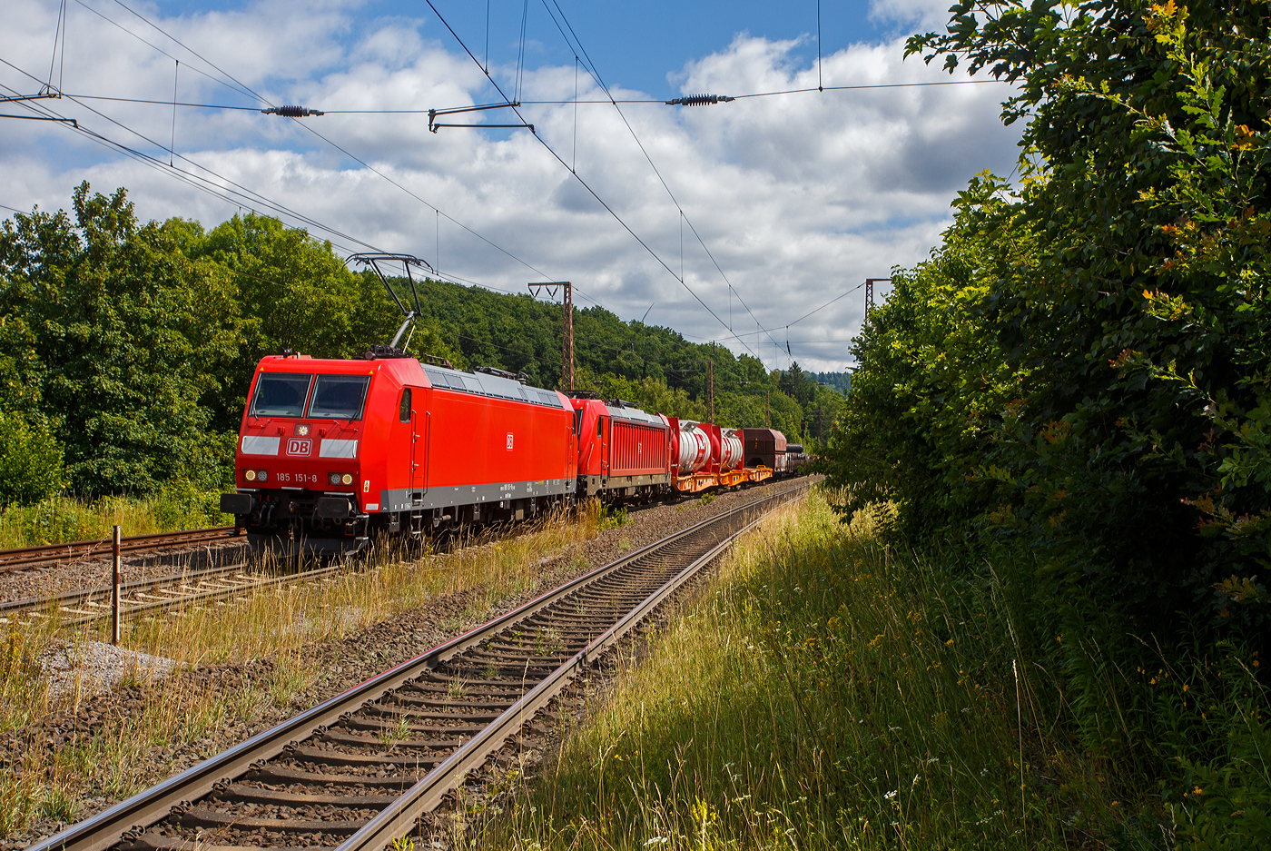 Die 185 151-8 (91 80 6185 151-8 D-DB) der DB Cargo AG fährt am 11 Juli 2025 mit der kalten 187 142-5 (91 80 6187 142-5 D-DB) und einem gemischten Güterzug durch Rudersdorf (Kr. Siegen) in Richtung Siegen.

Die TRAXX F140 AC1 (185 151-8) wurde 2002 von Bombardier in Kassel unter der Fabriknummer 33541 gebaut. Die TRAXX F140 AC3 (187 142-5) wurde 2017 von Bombardier in Kassel unter der Fabriknummer 35432 gebaut.
