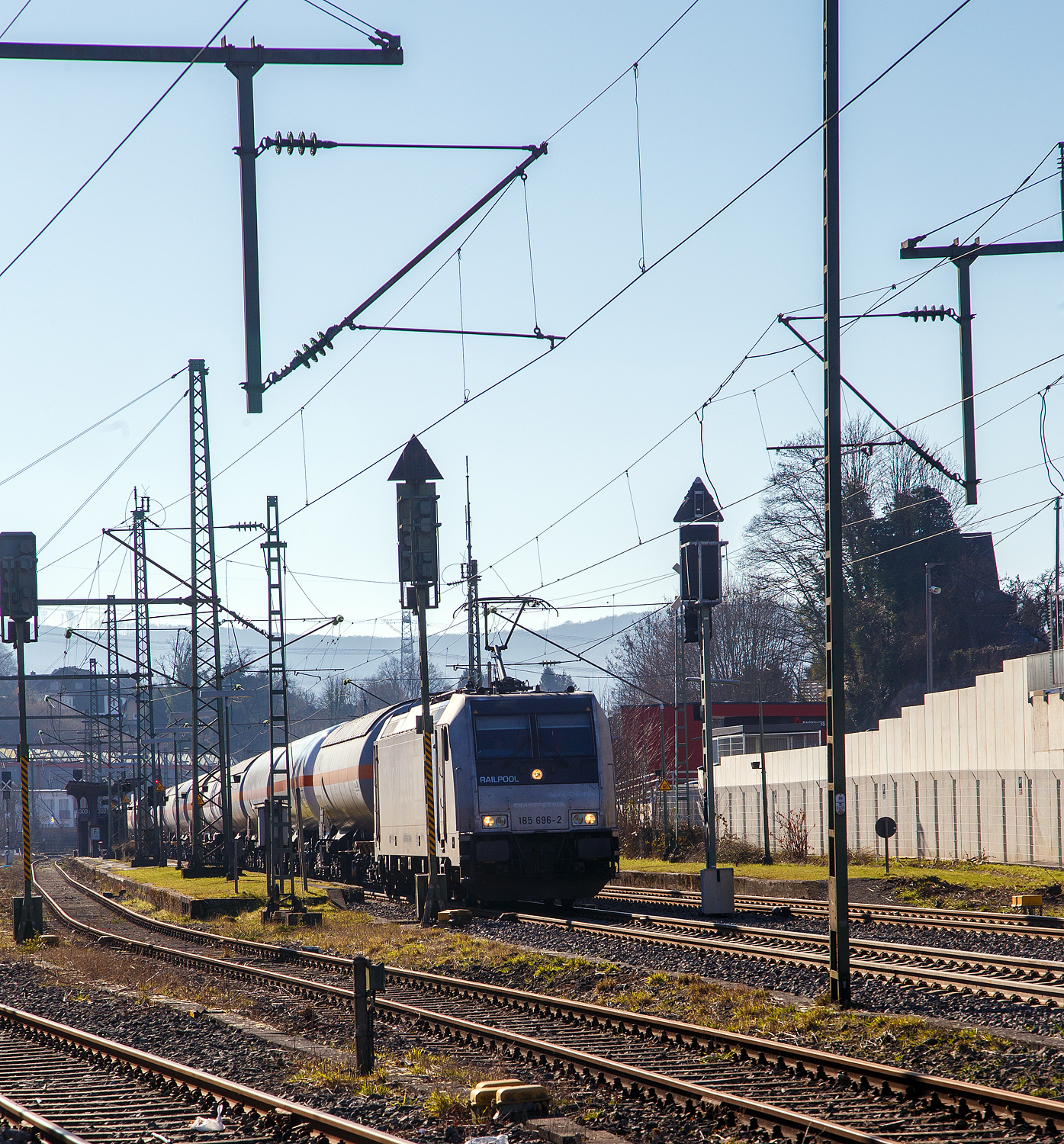 Die 185 696-2 „Marie-Chanthou“ (91 80 6185 696-2 D-Rpool) der Railpool fährt am 14.02.2023 mit einem Druckgas-Kesselwagenzug über die Siegstrecke (KBS 460) in Richtung Siegen. In Niederschelden (eigentlich Niederschelderhütte) hat sie kurz Hp 0, da die Schranken am Bü 343 (km 112,183) noch nicht geschlossen sind.

Die TRAXX F140 AC2 wurde 2010 von Bombardier in Kassel unter der Fabriknummer 34722 gebaut und an die Railpool geliefert. Die Lok ist für Deutschland und Österreich zugelassen. Die ehemaligen Zulassungen für Schweden und Norwegen sind nun durchgestrichen.).