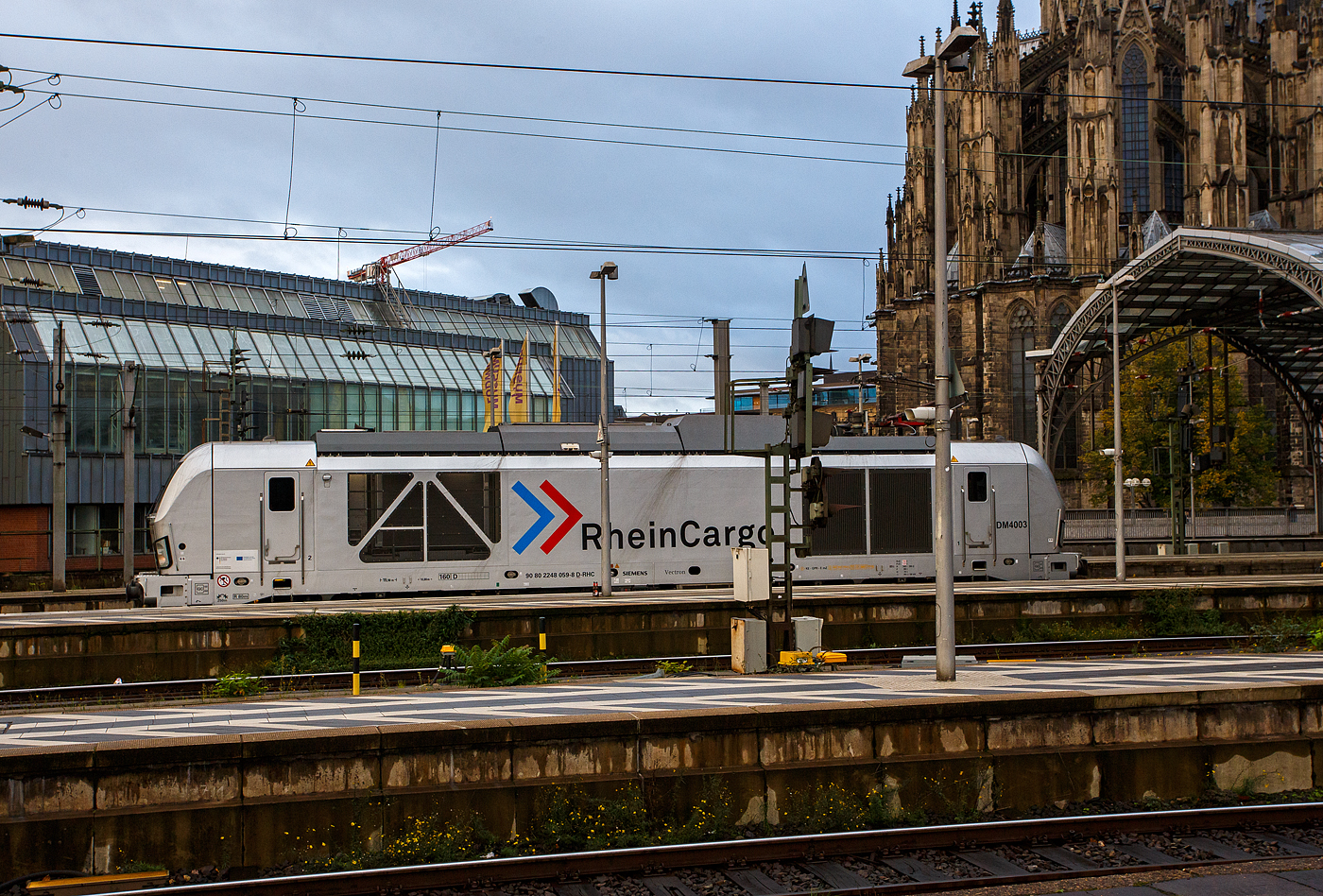 Die 248 059 alias DM4003 (90 80 2248 059-8 D-RHC), eine SIEMENS Vectron Dual Mode, der RheinCargo fährt am Morgen des 21 Oktober 2025, auf Tfzf (Triebfahrzeugfahrt) durch den Hauptbahnhof Köln in Richtung Deutz, im Hbf hatte sie kurz Hp 0.

Die SIEMENS Vectron DM wurde 2023 von der Siemens Mobility GmbH in München-Allach unter der Fabriknummer 23811 gebaut und im Oktober 2023 an die RheinCargo GmbH & Co. KG (Neuss) geliefert. Die Lok hat die Zulassung (160 km/h) nur für Deutschland. 

Die RheinCargo GmbH & Co. KG ist ein Gemeinschaftsunternehmen der Häfen und Güterverkehr Köln AG (HGK) und der Neuss-Düsseldorfer Häfen GmbH & Co. KG (NDH), die zu jeweils 50 % Eigentümer sind. Die Gesellschaft wurde 2012 gegründet. 