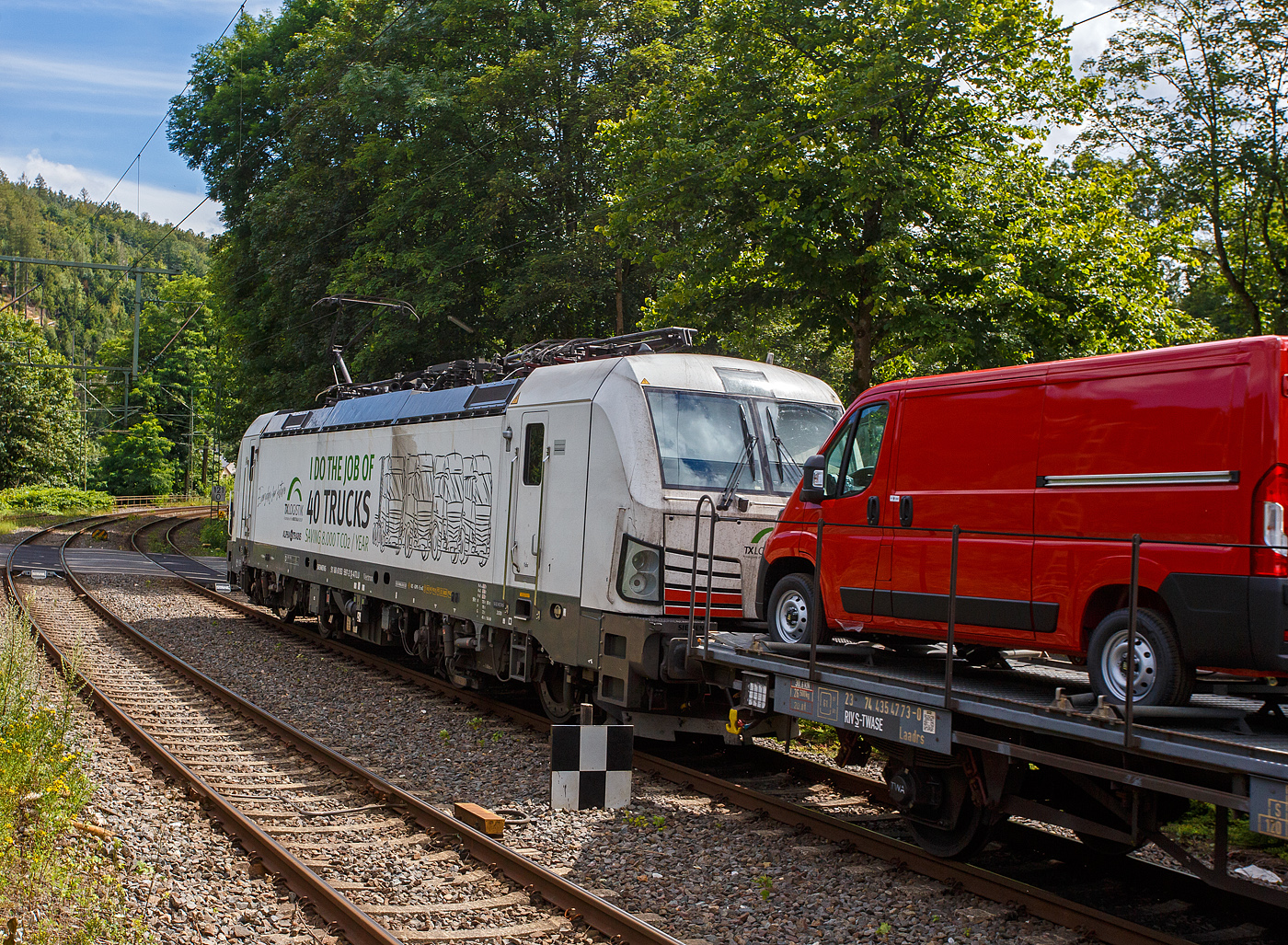 Die „wei�e“ an die TX Logistik AG (Bad Honnef) vermietete SIEMENS Vectron MS 193 597  I do the Job of 40 Trucks  (91 80 6193 597-2 D-ATLU) der Alpha Trains Luxembourg s.�.r.l. (Luxembourg) f�hrt am 14 Juli 2024, mit einem langen mit Nutzfahrzeuge (FIAT - Kastenwagen) beladenen Flachwagenzug (2 x 2 achsige Flachwageneinheiten), durch Kirchen (Sieg) in Richtung K�ln.

Nochmals einen lieben Gru� an den netten Lokf�hrer zur�ck.

Die Siemens Vectron MS wurde 2020 von Siemens Mobility GmbH in M�nchen-Allach unter der Fabriknummer 22865 gebaut und war erst als 91 80 6193 597-2 D-SIEAG der Siemens Mobility GmbH zugelassen. Im Jahr 2021 wurde sie an die Alpha Trains Belgium NV/SA in Antwerpen verkauft und ab Juni 2021 an die TX Logistik AG vermietet. 

Diese Vectron Lokomotive ist als MS – Lokomotive (Mehrsystemlok) mit 6.400 kW Leistung und 160 km/h H�chstgeschwindigkeit konzipiert. Hier in der Version A39 hat sie die Zulassungen f�r Deutschland, �sterreich, Schweiz, Italien, Niederlande und Belgien (D/A/CH/I/NL/B).Die SIEMENS Vectron MS der Version A 39 besitzt die Zugsicherungssysteme ETCS BaseLine 3, sowie
f�r Deutschland (PZB90 / LZB80 (CIR-ELKE I)), 
f�r �sterreich (ETCS Level 1 mit Euroloop, ETCS Level 2, PZB90 / LZB80),
f�r die Schweiz (ETCS Level 2, ZUB262ct, INTEGRA)
f�r Italien (SCMT)
f�r die Niederlande (ETCS Level 1, ETCS Level 2, ATB-EGvV)
und f�r Belgien (ETCS L1, ETCS L2, TBL1+)

TECHNISCHE DATEN der Vectron MS A39:
Spurweite: 1.435 mm (Normalspur)
Achsformel: Bo'Bo'
L�nge �ber Puffer: 18.980 mm
Drehzapfenabstand: 9.500 mm
Achsabstand im Drehgestell: 3.000 mm
Breite: 3.012 mm
H�he: 4.248 mm
Raddurchmesser : 1.250 mm (neu) / 1.160 mm (abgenutzt)
Gewicht: 90 t
Spannungssysteme: AC 15 kV 16,7 Hz und AC 25 kV 50 Hz (Wechselstrom), sowie DC 3 kV und DC 1,5 kV (Gleichstrom)
Max. Leistung am Rad: 6.400 kW (Fahren und Netzbremse)
Leistungsfaktor: nahe 1
H�chstgeschwindigkeit: 200 km/h
Anfahrzugskraft: 320 kN (optional 350 kN)
Dauerzugkrauft: 250 kN
Elektrische Bremskraft: 150 kN (240 kN mit erh�hte E-Bremskraft)
Kraft�bertragung: Ritzelhohlwellenantrieb
Kleinster befahrbarer Bogenradius (Strecke):	R 140 m
Kleinster befahrbarer Bogenradius (Depot): R 80 m
