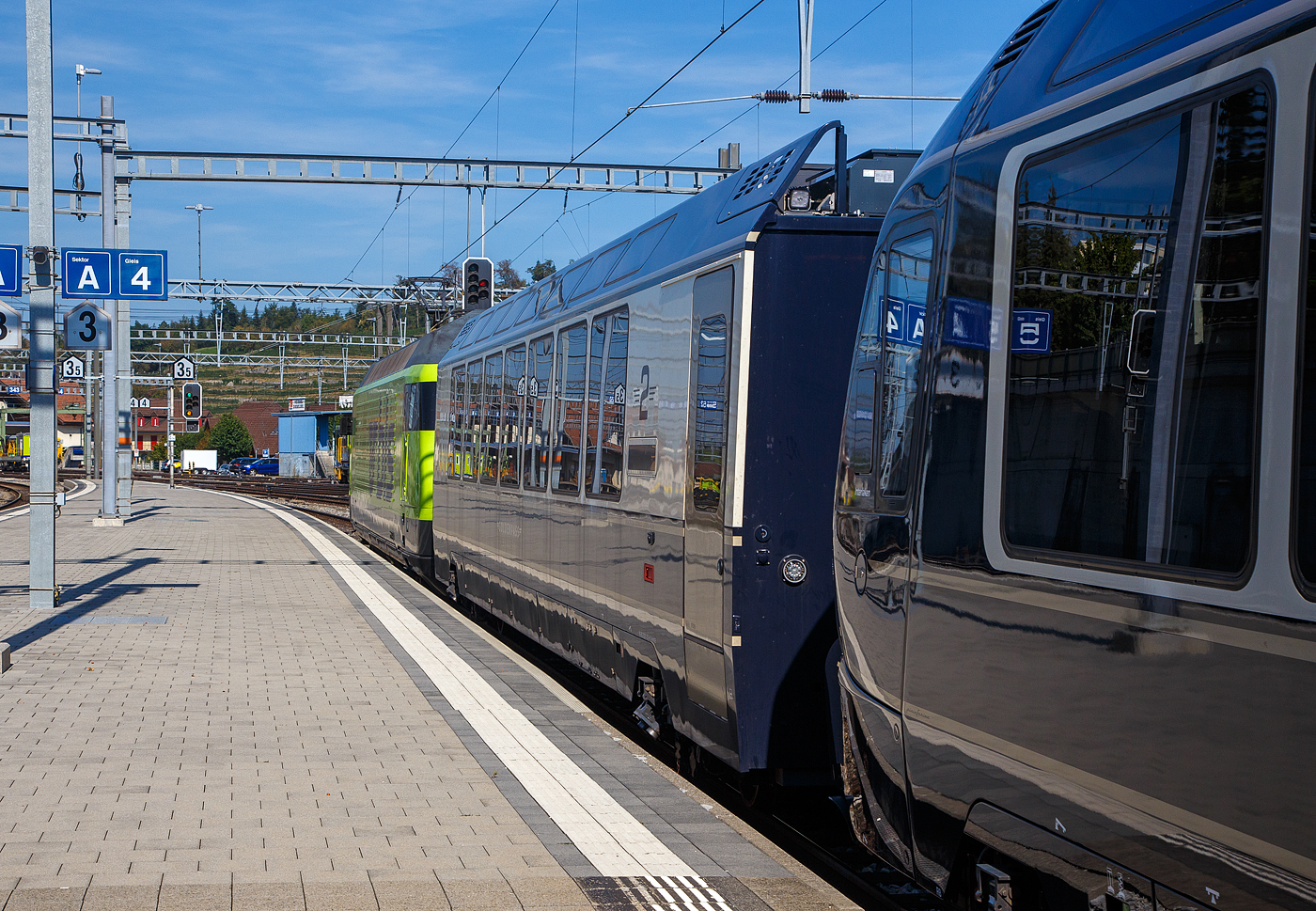 Die BLS Re 465 012 (91 85 4 465 012-3 CH-BLS) verl�sst am 11 September 2023, mit dem GoldenPass Express (GPX) von Interlaken Ost via Zweisimmen nach Montreux, den Bahnhof Spiez. 

Hier hinter der BLS Re 465 012 der 2. Klasse interface Wagen Bsi 292 (96 85 8300 292-5 CH-MOB), diesen Wagen (3 St�ck, Bsi 291 bis 293) sieht man meist NUR auf dem normalspurigen BLS-Netz. Der Interface-Wagen wird ben�tigt um die  Kommunikation zwischen der GPX-Stammkomposition und der BLS Lok Re 465 sicher zu stellen, so f�hrt er nur auf der BLS Normalspur, lediglich f�r die Fahrt in die MOB Werkst�tte (Chernex) muss er umgespurt werden.

Die Gr�nde f�r den zus�tzlichen Interfacewagen (Bsi) sind:
• Die normalspurigen BLS Loks haben Schaubkupplungen und zwei Puffer, und sind so nicht identisch mit den mittigen Schwab-Kupplungen der MOB. So hat der Interfacewagen an einem Ende (auf der Seite mit dem Hilfsf�hrerstand) Schraubenkupplung mit zwei Puffern und auf der gegen�berliegenden Seite �ber eine Schwab-Kupplung wie die anderen Wagen des Golden-Pass-Express.
• Die elektrische Spannung des MOB-Netzes entspricht nicht der Spannung des BLS-Netzes. So erf�llen diese Interfacewagen Aufgaben der Leittechnik, des Bremsens und der Energieversorgung des MOB GPX-Wagenzuges.

Die Wagen sind 18.900 mm �ber Puffer/Kupplung lang, das  Eigengewicht betr�gt  25.110 kg, und besitzt 54 Sitzpl�tze in der 2. Klasse. Wie auch die anderen GPX Wagen geh�ren sie der MOB.