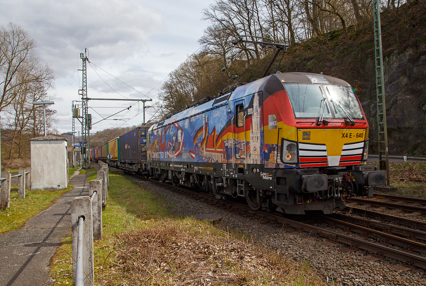 Die bunte und schöne an die TX Logistik AG vermietete Siemens Vectron MS X 4 E – 640 / 193 640-0 “Connected by Rail” (91 80 6193 640-0 D-DISPO) der MRCE Dispolok GmbH (München) fährt am 28.03.2023, mit einem KLV-Zug, durch Scheuerfeld (Sieg) Richtung Köln. 

Die Siemens Vectron MS - 6.4 MW wurde 2016 von Siemens in München-Allach unter der Fabriknummer 22164 gebaut. Sie hat die Zulassungen für Deutschland, Österreich und Italien, daher trägt sie auch die Werbung München, Kufstein, Verona (Connected by Rail). Sie hat eine Höchstgeschwindigkeit von 160 km/h.
