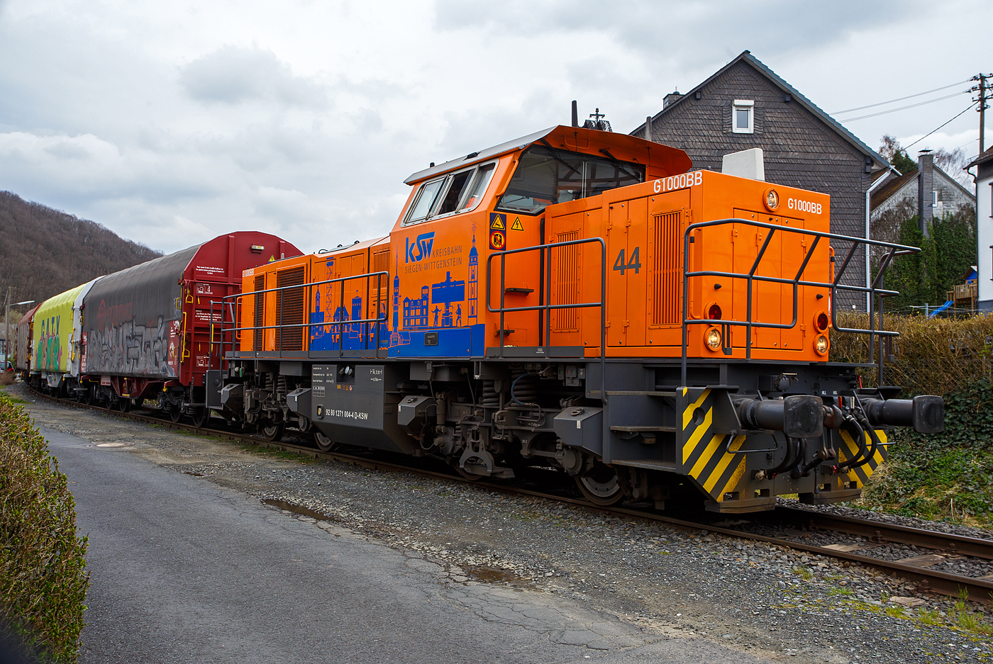 Die KSW 44 (92 80 1271 004-4 D-KSW) eine MaK G 1000 BB der KSW (Kreisbahn Siegen-Wittgenstein), mit einem leeren Coilzug vom Pfannenberg in Neunkirchen-Salchendorf kommend, am 22 März 2024 in Neunkirchen-Struthütten. So erreicht sie gleichdrauf den KSW-Rangierbahnhof in Herdorf, Betriebsstätte FGE -Freien Grunder Eisenbahn.

Die Lok 44 wurde 2003 unter der Fabriknummer 1001462 bei Vossloh gebaut und am 05.01.2004 an die SK - Siegener Kreisbahn GmbH geliefert, welche ab Ende 2004 nun als Kreisbahn Siegen-Wittgenstein (KSW) firmiert.