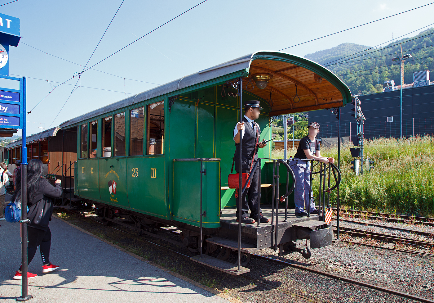 Die Lok muss nun ans andere Ende vom Zug, so wird der Wagenzug wieder etwas hochgedr�ckt.

Der zweiachsige 3. Klasse Personenwagen mit offenen Plattformen (Plattformwagen) ex CEG C 23 (Chemins de fer Electriques de la Gruy�re, ab 1942 GFM - Chemins de fer fribourgeois Gruy�re–Fribourg–Morat) der Museumsbahn Blonay-Chamby am 27.05.2023 im Zugverband im Bahnhof Blonay.

Der Wagen wurde 1903 von der SWS (Schweizerische Wagons- und Aufz�gefabrik AG, Schlieren) f�r die Chemins de fer �lectriques Veveysans (CEG) gebaut und als CEG C� 23 geliefert. Im Jahr 1967 ging der Wagen an die Museumsbahn Blonay-Chamby.

Die Chemins de fer �lectriques de la Gruy�re schloss sich 1942 mit den beiden Normalspurbahnen FMA und BR zur GMF (Chemins de fer fribourgeois Gruy�re–Fribourg–Morat) zusammen. Seit 2000 nun TPF (Transports publics fribourgeois SA / Freiburgische Verkehrsbetriebe AG).

TECHNISCHE DATEN:
Baujahr: 1903
Hersteller: SWS Schlieren (Schweizerische Wagons- und Aufz�gefabrik AG)
Spurweite: 1.000 mm (Meterspur)
Achsanzahl: 2
L�nge �ber Puffer: 8.900 mm
L�nge Wagenkasten: 7.900 mm (mit Plattformen)
Achsabstand: 4.300 mm
Eigengewicht: 7,3 t
Sitzpl�tze: 23 in der 3. Klasse