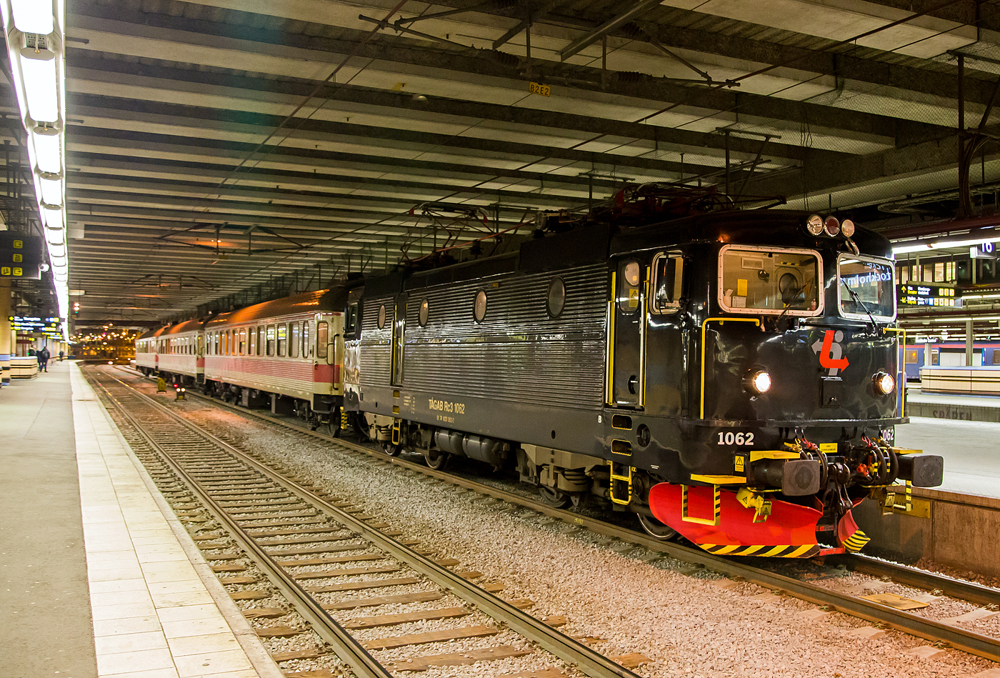 Die T�GAB Rc3 1062 (91 74 1031 062-2), T�GAB steht f�r T�g�keriet i Bergslagen AB, hat am 20.03.2019 mit einem Personenzug Stockholm Central erreicht.

Die Baureihe SJ Rc ist eine f�r die schwedische Staatsbahnen Statens J�rnv�gar (SJ) von ASEA zwischen 1967 und 1988 gebaute Elektrolokomotive. ASEA (Allm�nna Svenska Elektriska Aktiebolaget) war ein schwedisches Elektrotechnikunternehmen, 1988 legte der Konzern sein Gesch�ft mit der Schweizer BBC (Brown, Boveri & Cie) zur Asea Brown Boveri (ABB) mit Hauptsitz in Z�rich zusammen.

Die Rc Lokomotiven waren die ersten thyristorgesteuerten Serien-E-Loks in Schweden. Mit 366 in verschiedenen Varianten (Rc1 bis Rc7, sowie Rm) hergestellten Exemplaren ist die Baureihe die in Schweden am meisten verbreitete Lokbaureihe. Der Vorg�nger der Rc-Lokomotiven war eine umgebaute RB-Prototyplok. Vorteil der thyristorgesteuerten E-Loks ist der Einsatz von Gleichstrommotoren mit Stufenschalter und Diodengleichrichter, anstelle von Wechselstrommotoren. Ein Problem bei thyristorgesteuerten Rc-Lokomotiven besteht darin, dass sie starke St�rungen im Fahrdrahtnetz verursachen.

Der Lokkasten ist eine geschwei�te, selbsttragende Konstruktion. Die Seitenw�nde sind mit Sicken verst�rkt, die durch vier runde Bullaugen und eine T�re unterbrochen werden, zur Dachkante hin sind die L�ftergitter angebracht. Im Maschinenraum befinden sich mittig das Thyristor- und Transformatorger�t – beiderseits von Baugruppenschr�nken f�r Antrieb und Elektronik umgeben. Als Antrieb wird ein ASEA-Antrieb, bei Rc1 bis 4 vom Typ LJH 108, verwendet. Der Kasten ruht auf einer geschwei�ten Stahlblechkonstruktion, die an den Fronten die Zug- und Sto�vorrichtung aufnimmt. Rahmen und Lokkasten ruhen auf einem Wiegebalken, der auf vier Schraubenfedern und auf je zwei zweiachsigen Drehgestellen liegt. Die Zugkraft�bertragung erfolgt �ber zwischen Drehgestellen und Wiegebalken befindliche, diagonal angeordnete, Streben auf den Br�ckenrahmen.
Grunds�tzlich k�nnen bis zu drei Rc-Loks (einschlie�lich der aus ihnen abgeleiteten Type Rm und El 16) �ber eine Vielfachsteuerung miteinander verbunden und von einem F�hrerstand aus bedient werden.

Die Varianten der Rc-Reihe:
Baujahr ________ St�ck____ Gewicht ___ V-max ______ Zugkraft
Rc1 1967–1968 ___20 _____ 80,0 t ____ 135 km/h ____ 275 kN
Rc2 1969–1975 __100 _____ 76,8 t ____ 135 km/h ____ 275 kN
Rc3 1970–1971 ___10 _____ 76,8 t ____ 160 km/h ____ 235 kN
Rc4 1975–1982 __130 _____ 78,0 t ____ 135 km/h ____ 290 kN
Rc5 1982–1986 ___60 _____ 78,0 t ____ 135 km/h ____ 290 kN
Rc6 1985–1988 ___40 _____ 78,0 t ____ 160 km/h ____ 250 kN
Rm 1977 _________ 6 _____ 90,0 t ____ 100 km/h ____ 314 kN

Die Loks Rc6 1421 und 1422 erhielten zudem eine ge�nderte Getriebe�bersetzung f�r Geschwindigkeiten bis 180 km/h und deshalb die Bezeichnung Rc7. Allerdings erwies es sich als zu kostspielig, die Reisezugwagen f�r die erh�hte Geschwindigkeit mit Magnetschienenbremsen und anderen Details auszur�sten. Daher wurden die Rc7 1421 (2004) und 1422 (2003) wieder zu Rc6 zur�ckgebaut, behielten jedoch ihren dunkelblauen Anstrich.

TECHNISCHE DATEN der Rc3:
Spurweite:  1.435 mm (Normalspur)
Achsformel: Bo'Bo'
L�nge �ber Kupplung: 15.520 mm
Drehzapfenabstand: 7.700 mm
Treibraddurchmesser:  1.300 mm 
Gewicht: 76,8 t
H�chstgeschwindigkeit: 160 km/h
Leistung: 3.600 kW
Anfahrzugkraft: 235 kN
Stromsystem: 15 kV 16 2/3 Hz ~