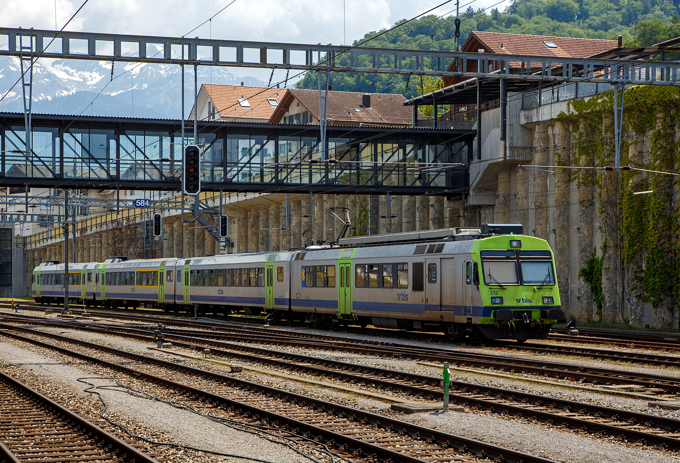 Ein BLS NPZ ist am 28.05.2023 beim Bahnhof Spiez abgestellt. 
Der sogenannte «Privatbahn-NPZ» besteht hier (vierteilig) aus:
•	Triebwagen RBDe 566 232-5 (94 85 7 566 232-5 CH-BLS), ex EBT RBDe 4/4 II – 232 (Emmental-Burgdorf-Thun-Bahn, seit 2006 BLS);
•	2. Klasse Zwischenwagen (Lieferung 1991–92) B 50 85 20-35 517-5 CH-BLS, ex EBT B 50 38 20-34 517;
•	1./2. Klasse Steuerwagen Abt 932 / 50 85 80-35 932-3 CH-BLS, ex EBT ABt 50 38 39-33 932, ex EBT Bt 932, sowie dem weiteren
•	1./2. Klasse Steuerwagen ABt 933 / 50 85 80-35 933-1 CH-BLS, ex EBT ABt 50 38 39-33 933, ex EBT Bt 933.

Die ursprünglichen RBDe 4/4II der EBT-Gruppe, heute RBDe 566-II (230–242), sind Pendeltriebzüge (Elektro-Triebwagen mit Zwischen- und Steuerwagenwagen) für den Einsatz im Regionalverkehr der BLS AG. Zusammen mit der zweiten Serie der BLS RBDe 565 beschaffte 1984 bis 85 auch die EBT-Gruppe (ab 1997 RM - Regionalverkehr Mittelland, seit 2006 BLS) 13 sogenannte «Privatbahn-NPZ». Diese sind mit den Zügen der BLS weitestgehend identisch, außer dass die Steuerwagen ohne 1. Klasse als Bt gebaut wurden. Zudem ist die Adernbelegung der Vst III unterschiedlich. In den Jahren 1991/92 erhielten alle EBT/SMB/VHB-Steuerwagen ein 1. Klasse Abteil und wurden so zu ABt. Die RBDe 4/4 erhielten die Bezeichnung RBDe 566, die Steuer- und Zwischenwagen erhielten 1991/92 zwölfstellige UIC-Nummern. Die RM-Nummern wurden nach der Fusion mit der BLS Mitte 2006 beibehalten. 

Ab 2009 durchliefen die Züge eine Modernisierung analog den RBDe 565, außer jenen Punkten, die bei den RBDe 566 II bereits ausgeführt sind. Dabei werden auch die ehemaligen RM-Nummern durch TSI-Nummern ersetzt. Bei den Zwischenwagen erfolgte dies konzentriert im Jahre 2011. Die Kompositionen wurden nach und nach von Rot auf das Lindengrün der BLS umlackiert.

Die Triebwagen werden nach und nach verschrottet und durch den neuen MIKA ersetzt. Die Steuerwagen ABt 50 85 80-35 930, 931, 934, 935, 936, 939 und 940 werden zu BDt für die Autopendelzüge umgebaut. Sie werden zusammen mit den modernisierten Re 465 im Einsatz sein.

TECHNISCHE DATEN Triebwagen:
Spurweite: 1.435 mm (Normalspur)
Achsfolge: Bo'Bo' 
Länge über Puffer: 25.000 mm 
Drehzapfenabstand: 17.500 mm
Achsabstand im Triebdrehgestell: 2.700 mm
Gewicht: 72,0 t 
Dauerleistung: 1.650 kW / 2.240 PS
Anfahrzugkraft: 164 kN
Höchstgeschwindigkeit: 125 km/h
Sitzplätze: 55 in der 2. Klasse
Max. Ladegewicht: 4 t
Stromsystem: 15 kV 16⅔ Hz AC

Quellen: BLS, wikipedia
