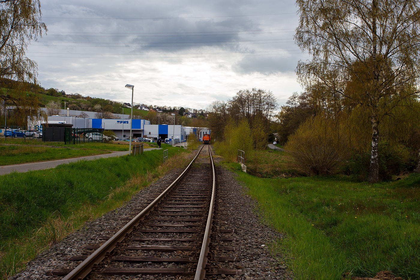 Ein langer und schwerer Coilzug im Sandwich der Kreisbahn Siegen-Wittgenstein fährt am 16 April 2026 in Neunkirchen-Struthütten auf der Freien Grunder Eisenbahn (KSW-Infrastruktur) in Richtung Neunkirchen-Salchendorf. Vorne die führende KSW 45 (98 80 0276 016-9 D-KSW) die MaK G 1204 BB. Am Zugschluss ist die nachschiebende KSW 42 (92 80 1277 902-3 D-KSW), eine Vossloh MaK G 1700 BB.