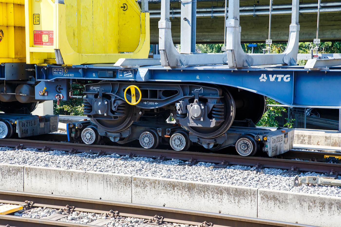 Ein normalspuriges Drehgestell des leeren 2 x vierachsiger Flachwagen in Sonderbauart (INNOFREIGHT Holz-Doppelwagen), 37 80 4657 028-9 D-VTG, der Gattung Sggmrrs S240, verladen auf zwei schmalspurige Rollböcke Ua 2xx vom Typ Vevey, am 07 September 2023 an einer Rollbockgrube beim Bahnhof Morges.

Die Rollböcke dienen zum Transport von Normalspurwagen (meist Güterwagen) auf Schmalspurgleisen (wie hier 1.000 mm). Ein Rollbock ist 1,65 t schwer und trägt jeweils eine Normalspur-Wagonachse mit einer maximalen Achslast von 22,5 t. Bei z.B. einem vierachsigen Drehgestell Wagen kommen so vier Rollböcke zum Einsatz, wobei der Wagen somit bis zu 90 t schwer sein kann.

TECHNISCHE DATEN:
Spurweite: 1.000 mm
Achsanzahl: 2
Eigengewicht: 1,65 t
Traglast: 22,5 t 

Ein Rollbock ist ein meist zweiachsiges Schienenfahrzeug (Wagen), mit dem ein andersspuriges Eisenbahnfahrzeug auf der Spurweite des Rollbocks befördert werden kann. In Süddeutschland wird er auch als Rollschemel bezeichnet, nicht aber in der Schweiz, wo dieses Wort einen Rollwagen bezeichnet. Entwickelt wurde der Rollbock 1881 von Paul Langbein (1842–1908).

Funktion:
Durch den Einsatz von Rollböcken entfällt im Güterverkehr das Umladen der Güter in Fahrzeuge der anderen Spurweite. Das Aufbocken von Personenwagen war nicht üblich, da die Reisenden selbst relativ leicht die Fahrzeuge wechseln konnten und das Kipp-Risiko bei Personenbeförderung nicht akzeptabel war. Zu besonderen Anlässen wurden aber Spezialwagen verladen, beispielsweise Salon- oder Kinowagen. Grundsätzlich ist anzumerken, dass es, insbesondere in Deutschland, kein zusammenhängendes Schmalspurnetz, ähnlich jenem in Normalspur, gibt oder gab. Daher war eine weitgehende Normung und Standardisierung, die bei den normalspurigen Eisenbahnen die Interoperabilität sicherstellt, nicht zwingend und fand nicht statt. Folglich kam es zu zahlreichen technischen Insellösungen, auch bei den Rollböcken. Die grundsätzliche Funktion ist aber stets dieselbe. Neben technischen Unterschieden waren daraus folgend die Vorschriften für den Betrieb verschieden, wobei die Vorschriften zum Teil die Technik beeinflussten, zum Teil aber auch in der Folge der technischen Voraussetzungen erlassen wurden.

Rollböcke werden seitens der Eisenbahnindustrie im Übrigen auch dafür eingesetzt, andersspurige Fahrzeuge über Normalspur vom Hersteller zu Testeinrichtungen oder zu ihrem Einsatzgebiet zu transportieren. So setzt die RailAdventure GmbH solche Fahrzeuge – bei ihr Loco Buggys genannt – ein.

Technik
Der Rollbock ist ein schmalspuriges Fahrzeug mit sehr kurzem Achsstand (ähnlich einem Drehgestell), auf dem die Räder jeweils eines Radsatzes des Normalspurwagens verankert werden. Beladen wird der Rollbock von einer speziellen Rollbockgrube aus. Abhängig von der konkreten Ausgestaltung der Rollböcke konnten auch dreiachsige Wagen aufgebockt werden. 

Güterwagen auf Rollböcken (oder Rollwagen) können zu ganzen Güterzügen zusammengestellt werden. Je nach örtlicher Betriebsvorschrift konnten schmalspurige Personenwagen in die Züge eingereiht werden, häufig waren die Reihungsfolgen reglementiert. Zum Teil waren bzw. sind die Rollböcke mit dem jeweiligen Bremssystem (Druckluft, Saugluft) oder Heberleinbremse der Schmalspurbahn ausgerüstet, es gab aber auch ungebremste Rollböcke. Einige Bahnen stellten in diesem Fall so genannte Bremswagen in die Züge ein, die ballastiert waren, um größeres Bremsvermögen zu besitzen. Teilweise wurden die Bremsleitungen der Normalspurwagen mitverwendet und die Rollbockbremsen über T-Stücke an diese angeschlossen. Normalspurwagen auf Rollböcken werden entweder direkt miteinander gekuppelt oder die Rollböcke mittels Kuppelstangen verbunden. Bei der direkten Kupplung sind diese „lang zu machen“, das heißt, nicht straff anzuziehen, da die Puffer die Wagen in den häufig engen Radien sonst von den Rollböcken drücken würden. Die Verbindung mit dem Zugfahrzeug kann ebenfalls über Kuppelstangen erfolgen. Es gibt aber auch die Möglichkeit, so genannte Pufferwagen zu verwenden. Diese schmalspurigen Wagen besitzen Zug- und Stoßvorrichtungen, die in Ausführung und Höhe zu jenen der aufgebockten Normalspurwagen passen und somit als Adapter dienen. Es wurden auch Lokomotiven mit solchen angepassten Normalspur-Zug-und-Stoßvorrichtungen verwendet.

Rollböcke nach dem System Vevey
Um den beim System Langbein personal- und zeitaufwändigen Verladevorgang zu vereinfachen, entwickelte die schweizerische Bahngesellschaft YSteC 1974 ein neues Prinzip. Hierbei wird die Achse des Normalspurwagens nicht mehr fixiert. Der Wagen steht mit seinen Rädern in speziell geformten Mulden. Derartige Rollböcke, als System „Vevey“ von den Ateliers de constructions mécaniques de Vevey (ACMV) in Serie gefertigt, werden bei mehreren Bahnen in der Schweiz und einer Bahn in Deutschland (HSB) eingesetzt. Der Hauptunterschied zum klassischen Rollbock ist, dass das Aufbocken bei langsamer Fahrt automatisch geschieht. Somit sind zahlreiche Unannehmlichkeiten und Gefährdungspotenziale behoben, weswegen beispielsweise die Harzer Schmalspurbahnen ihre Rollwagen durch solcherlei Rollböcke ersetzt haben, ähnlich wie zuvor diverse Schweizer Bahnen.

Die mögliche Rationalisierung konnte aber nicht verhindern, dass der Güterverkehr auf zahlreichen Schmalspurbahnen dennoch eingestellt wurde. Rollbockanlagen im kommerziellen Betrieb gibt es nur noch in Nordhausen, Langenthal, Morges und Yverdon, die Anlage in Worblaufen dient noch Diensttransporten. In Interlaken Ost wurde 2021 eine neue Rollbockanlage erstellt.
