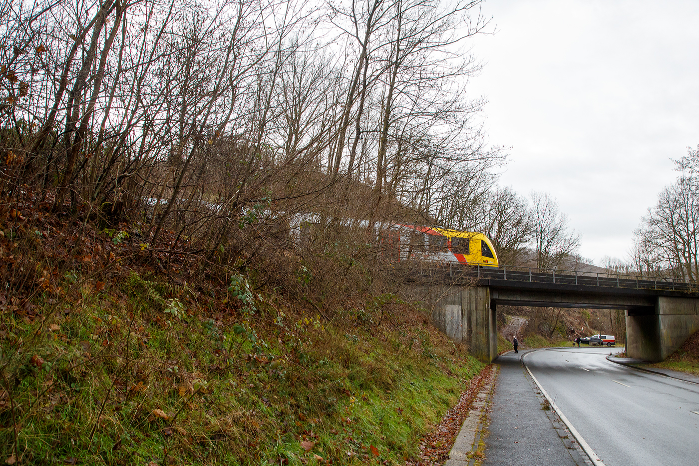 Glück im Unglück.....
Herdorf den 23. Dezember 2022 ca. 18:15 Uhr (Bild vom 24.12.)
Zug entgleist in Herdorf kurz hinter dem Hp  Königsstollen (bei km 88,4) – Fahrgäste kommen mit dem Schrecken davon. Wie sich kurze Zeit später herausstellte hatte ein Erdrutsch dazu geführt. Hier im Bild der havarierte Triebwagen VT 507.
	
Der Diesel-Triebwagen VT 507 (95 80 1648 107-8 D-HEB / 95 80 1648 607-7 D-HEB), ein Alstom Coradia LINT 41 der neuen Generation, der HLB (Hessische Landesbahn GmbH), war am 23.12.2022 (Bf Herdorf ab 18:10 Uhr), als RB 96  Hellertalbahn  Neunkirchen - Herdorf - Betzdorf (Umlauf 61790) von Herdorf nach Betzdorf unterwegs. Kurz hinter dem Hp Königsstollen (bei km 88,4) kam es zu einen Erdrutsch zum Teil mit Felsbrocken, als gerade der Triebwagen die Stelle passierte, entgleiste das vorderen Drehgestell. Der Triebwagen mit Passagieren ist im Gleisbett geblieben und nach ca. 100 m er an der Eisenbahnbrücke, die über die Landesstraße führt, zum Stehen. Die ca. 15 Fahrgästen und der Treibfahrzeugführer kamen Dankbarerweise nicht zu Schaden. Da der Hp  Königsstollen ein Bedarfshalt ist, reduziert (wenn er nicht gehalten hat) der Treibfahrzeugführer zum Glück eh die Geschwindigkeit, in voller Fahrt hätte es anders ausgehen können.

Der Treibfahrzeugführer erklärte den Fahrgästen die Situation. Kurze Zeit später trafen die Rettungskräfte ein. Dank einer als provisorische Treppe umfunktionierten Steckleiter, an der Böschung am Wiederlager der Brücke, konnten Feuerwehrleute die Fahrgäste innerhalb von 15 Minuten wohlbehalten nach unten zur Landesstraße geleiten.

Die Polizei gibt als Ursache für den Erdrutsch die Witterungsbedingen an. Die Strecke bleibt bis mindestens Dienstag 27.12.2022 gesperrt sein, weil ein Spezialzug zur Bergung benötigt wird. Neben Erdreich sind auch massive Felsbrocken infolge des Hangrutsches auf dem Gleisbett gelandet, diese müssen auch erst weggeräumt werden, dafür braucht man auch Großgerät und über die Feiertage muss man auch erstmal noch eine Firma bekommen.

Im Einsatz waren neben dem Rettungsdienst und Polizei 40 Kräfte der Löschzüge Herdorf, Sassenroth und Daaden. Die anliegende Landesstraße musste aufgrund der eingesetzten Rettungskräfte ebenfalls voll gesperrt werden. Die Ermittlungen wurden von der zuständigen Bundespolizei übernommen.

Interessant ist die Tatsache das auf der einen Seite vom Gleis bereits umfangreiche Hangsicherungsmaßnahmen stattgefunden haben. Und die andere Seite noch nicht gesichert war.

Quellen: Rhein Zeitung, DPA und eigene Recherchen

Link zum Artikel der Rhein Zeitung:
http://www.rhein-zeitung.de/region/aus-den-lokalredaktionen/kreis-altenkirchen_artikel,-zug-entgleist-bei-herdorf-fahrgaeste-kommen-mit-dem-schrecken-davon-_arid,2486964.html
