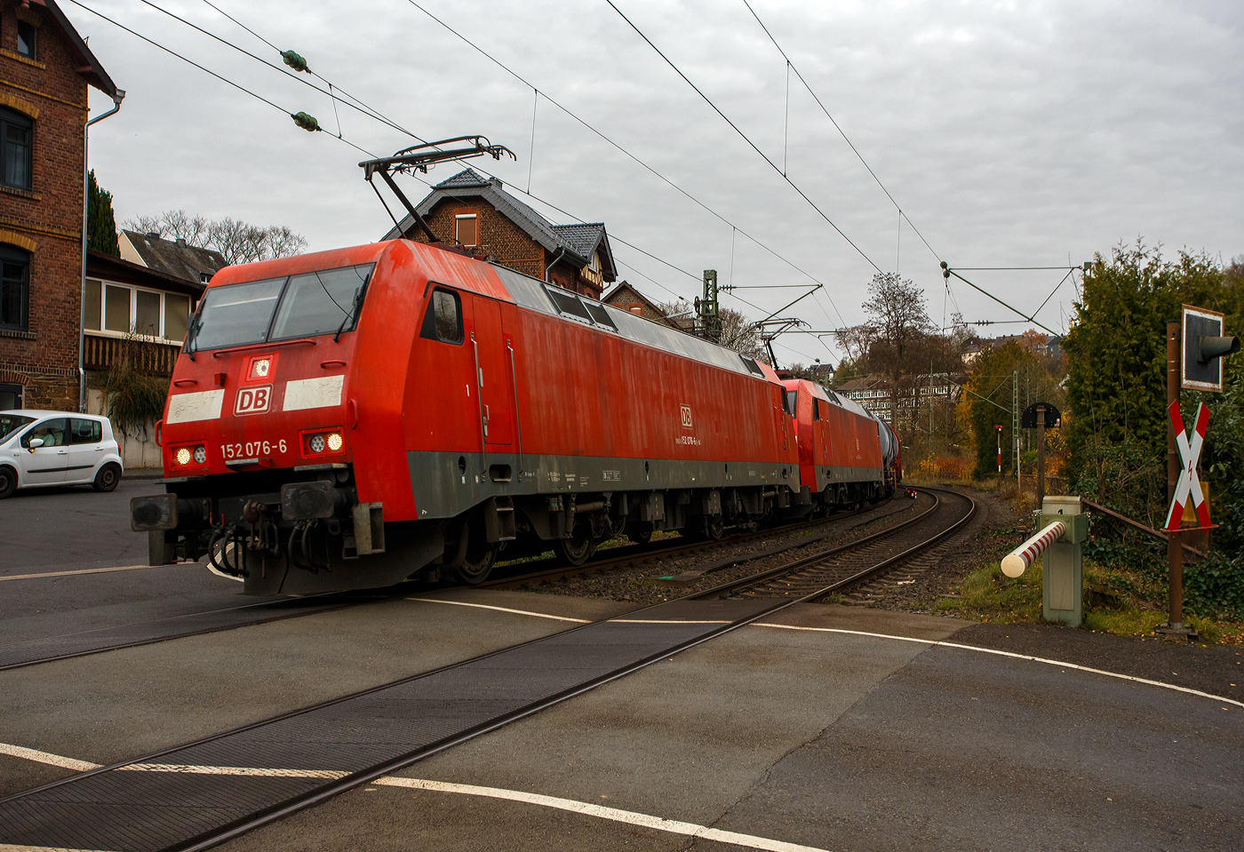 In Doppeltraktion die 152 076-8 (91 80 6152 076-6 D-DB) und die 152 009-7 (91 80 6152 009-7 D-DB) beide der DB Cargo Deutschland AG fahren mit einem gemischten Güterzug am 14 November 2025 durch Kirchen/Sieg, hier beim Bü km 121,192, in Richtung Köln. Vermutlich hatten die beiden Siemens ES 64 F zuvor im Bahnhof Hp0, denn deutlich konnte ich bei der Anfahrt hören, dass die Loks mit dem langen Zug am Arbeiten waren um ihre um ihre 17.400 PS (12.800 kW) Leistung auf die Schiene zu bekommen.

Die 152 076-8 wurde 1999 von der Krauss-Maffei AG (heute Siemens) in München-Allach unter der Fabriknummer 20203 gebaut, die Elektrik wurde von DUEWAG unter der Fabriknummer 91953 geliefert. Die 152 009-7 wurde 1998 er Krauss-Maffei AG in München-Allach unter der Fabriknummer 20136 gebaut.

Die DB Baureihe 152 (Siemens ES64F):
Für den Güterverkehr benötigte die Deutsche Bahn Mitte der 1990er-Jahre dringend neue leistungsstarke Lokomotiven. Als Teil des  großen Beschaffungsprogramms für Triebfahrzeuge  der Deutschen Bahn AG wurde nach einer im Jahr 1993 erfolgten Ausschreibung über drei Lokomotivbaureihen 1995 ein Vertrag zwischen DB AG und Krauss-Maffei Verkehrstechnik GmbH (mit dem Partner Siemens) über die Lieferung von 195 Güterzuglokomotiven der oberen Leistungsklasse der Baureihe 152 geschlossen. Der Vertrag beinhaltet eine Option über 100 weitere Lokomotiven, die in direktem Anschluss an die erste Serie zu liefern wären, d. h. in den Jahren 2001 bis 2003.

Technische Basis des Angebots und des Vertrags war die gemeinsam von Krauss-Maffei und Siemens entwickelte EuroSprinter-Familie. Aufgrund des modularen Konzepts der EuroSprinter-Familie und der positiven Betriebserfahrungen in Spanien, Portugal und in Deutschland konnten die technischen Verhandlungen, ausgehend vom funktionalen Lastenheft der DB AG, sehr zielstrebig und effizient geführt werden.

Bei Bau und Entwicklung der neuen Lokomotiven wurde auf neueste Erkenntnisse der Technik Rücksicht genommen. Der Führerstand verfügt über eine Klimaanlage und sogar ein Getränke-Kühlfach für den Lokomotivführer. Zur besseren Sicht bei Dunkelheit wurden, wie auch bei der Baureihe 101, Fernscheinwerfer eingebaut. Interessant sind bei diesen Lokomotiven auch die außen liegenden Scheibenbremsen. Zum Schutz der Umwelt wurden umweltverträgliche Kühlmittel und Lacke auf Wasserbasis verwendet. Die Baureihe 152 hat sich seitdem sehr gut bewährt und läuft, im Gegensatz zur 101, auch weitgehend störungsfrei.

Die ersten vier Lokomotiven wurden bereits 1997 in Betrieb genommen und mit Zulassung des Eisenbahn-Bundesamtes (EBA) geliefert. Ab 1998 lief die Serienlieferung planmäßig. Die ersten zehn Lokomotiven wurden seit dem Fahrplanwechsel im Mai 1998 in einem zehntägigen Umlauf Padborg - Basel eingebunden. Sie zeigten bisher keine Auffälligkeiten und arbeiten zur Zufriedenheit des Betriebes.

Die Abnahmefahrten erbrachten die Bestätigung, dass die im Lastenheft geforderte Leistungsfähigkeit in den vollen Umfang realisiert wurde. Anlässlich einer Vorführfahrt in Österreich wurde die Leistung sogar auf 7 MW gesteigert. Teilweise wurden schwere Güterzüge mit nur drei Motoren gefahren und in keinem der Fälle wurden die thermischen Grenzwerte der Bauteile erreicht. Bei einer Vorführfahrt durch die Schweiz nach Italien wurde ein 3.200-t-Tonerde-Zug mit über 640 kN Anfahrzugkraft in Doppeltraktion ruckfrei angefahren. Damit konnten die bei der Leistungsauslegung eingebauten Reserven wirkungsvoll nachgewiesen werden.

Die BR 152 ging in den Lokomotivbestand von der DB Cargo AG (zeitweise unter Railion bzw. DB Schenker Rail firmiert) ein und sollte dort in erster Linie die sechsachsigen Lokomotiven der BR 150 bzw. 151 ersetzen. Die Lokomotive kann aber auch im Personenverkehr eingesetzt werden. So ist die BR 152 dank hoher Leistung und Zugkraft z.B. sehr gut für schwere Doppelstockzüge im Wendezugbetrieb geeignet.

Zur Auslieferung aller bestellten 195 Stück der 152er kam es allerdings nicht, da wegen einer geringfügigen Überschreitung der Achslasten bekam die neue Baureihe bei der Österreichischen Bundesbahn (ÖBB) keine Zulassung. Man musste handeln. Die neuen Lokomotiven wurden dringend für den Güterverkehr nach Österreichisch benötigt, für eine weitere Neuentwicklung waren weder Zeit noch Geld vorhanden. So wurde die Bestellung über die letzten 25 Stück der BR152 storniert und in die Zweisystemloks Siemens ES64U2 (baugleich mit ÖBB Reihe 1116 - Zweisystemloks „Taurus“) umgewandelt. Diese Lokomotiven wurden im Jahr 2001 ausgeliefert und sind seitdem als Baureihe 182 bei der DB Cargo AG im Dienst.

Konstruktion:
Die Baureihe basiert auf dem von Siemens konstruierten Prototyp ES64P (127 001). Da jedoch klar war, dass die Maschinen doch ausschließlich im Güterverkehr eingesetzt werden sollten und eine Höchstgeschwindigkeit von 140 km/h als ausreichend angesehen wurde, konnte auf die Verwendung von voll abgefederten Fahrmotoren verzichtet und auf den wesentlich einfacheren und preisgünstigeren Tatzlager-Antrieb zurückgegriffen werden. Dieser gilt durch die Verwendung moderner Drehstrommotoren bei niedrigen Geschwindigkeiten als relativ verschleißarm. Die Kraftübertragung zwischen Wagenkasten und Drehgestellen erfolgt in Maffei-Tradition über kräftig dimensionierte und tief herunterreichende Drehzapfen sowie Flexicoilfedern.

Ansonsten entstand eine moderne Maschine mit Drehstromasynchron-Fahrmotoren und doppelten innenbelüfteten Scheibenbremsen. Eine teilredundante Ausführung von hochbeanspruchten Teilen im Antriebsstrang trägt ganz wesentlich zur hohen Zuverlässigkeit und Verfügbarkeit der Baureihe bei.

Der Haupttransformator ist unterflur zwischen den Drehgestellen angeordnet. Jedes Drehgestell verfügt über eine autarke elektrische Ausrüstung, bestehend aus drei Eingangsgleichrichtern in rückspeisefähiger Vierquadranten-Bauweise, Gleichspannungszwischenkreis und zwei Wechselrichtern (einer je Motor). Dadurch wird erreicht, dass bei Ausfall einer Komponente des Antriebsstrangs nicht das gesamte Drehgestell ausfällt, sondern sich lediglich die verfügbare Zugkraft reduziert. Als Leistungshalbleiter kommen wassergekühlte GTO-Thyristoren zum Einsatz. Die Bremskraft der elektrodynamischen Nutzbremse beträgt 150 kN im Bereich zwischen 10 km/h und 140 km/h.

Die Lokomotiven sind mit Zugsammelschiene für die Energieversorgung von Reisezügen sowie Wendezugsteuerung und Notbremsüberbrückung ausgerüstet, so dass sie auch im schweren Personenzugdienst eingesetzt werden können. Durch die Aufteilung der DB AG und Zuordnung der Loks zum Geschäftsbereich Güterverkehr der DB wurde davon seit Ende der 1990er Jahre kein Gebrauch mehr gemacht.

Der Maschinenraum wird von einem beide Führerstände verbindenden Mittelgang durchzogen. Beidseitig sind an den Außenwänden des Lokkastens die elektrische Ausrüstung, die Druckluft- und Bremsgeräte sowie die umfangreichen Kühleinrichtungen angeordnet. Alle Aggregate sind in Form von separaten, austauschbaren Modulen ausgeführt, die von oben in das Fahrzeug eingebracht werden. Dabei wurde auf möglichst kurze Verbindungen, insbesondere bei den Hauptstromleitungen geachtet. Die Steuerleitungen und die Verrohrung sind in Kanälen unter dem Mittelgang verlegt. Die Steuerungs- und Überwachungsgeräte sind an den beiden Enden des Maschinenraums konzentriert.

Die Führerstandsräume sind klimatisiert, wärme- und schallisoliert und verfügen über ein recht großzügiges Raumangebot. Annehmlichkeiten für den Triebfahrzeugführer sind darüber hinaus ein luftgefederter Sitz und ein Thermofach. Die Lokomotiven sind mit Einheitsführerständen ausgerüstet.

TECHNISCHE DATEN der BR 152 (Siemens ES64F):
Hersteller: Krauss-Maffei bzw. Siemens 
Baujahre: 1996-2001
Gebaute Anzahl: 170
Spurweite: 1.435 mm (Normalspur)
Achsformel: Bo´Bo´
Länge über Puffer: 19.580 mm
Drehzapfenabstand: 9.900 mm
Achsstand im Drehgestell: 3.000 mm
Treibraddurchmesser: 1.250 mm (neu) / 1.170 mm (abgenutzt)
Breite: 3.000 mm
Dienstgewicht: 86,7 t
Achslast: 21,75 t
Höchstgeschwindigkeit: 140 km/h
Dauerleistung: 6.400 kW (8.701 PS)
Anfahrzugkraft: 300 kN
Dauerzugkraft: 250 KN
Fahrmotoren: 4 Stück fremdbelüftete vierpolige Drehstrom-Asynchron-Motoren vom Typ Siemens 1TB2822-0SC02 (Gewicht/Motor 2.880 kg)
Getriebeübersetzung: 3,95:1
Antriebsart: integrierter Tatzlagerantrieb
Stromabnehmer: SSS 87 (Einholm)
Stromsystem: 15 kV, 16 2/3 Hz

Elektrisches Antriebssystem: Wassergekühlte GTO-Stromrichter, 3 netzseitige Eingangsgleichrichter (4QS), Gleichspannungszwischenkreis, 1 Pulswechselrichter pro Fahrmotor, Einzelachsregelung mit 75% Redundanz. 

Steuerungs- und Leittechnik: 2 Zentrale Steuergeräte in SIBAS 32 mit integrierter AFB, ZWG, SIFA und zentraler Diagnose, 1 Farbdisplay und MFA pro Führerstand, LZB 80, Gleit- und Schleuderschutz K-Micro.

Bremsausrüstung: Elektrische Netzbremse, Knorr-Führerbremsventilanlage Typ HSM-MEP, Radscheibenbremse, 4 Federspeicher-Festhaltebremsen
