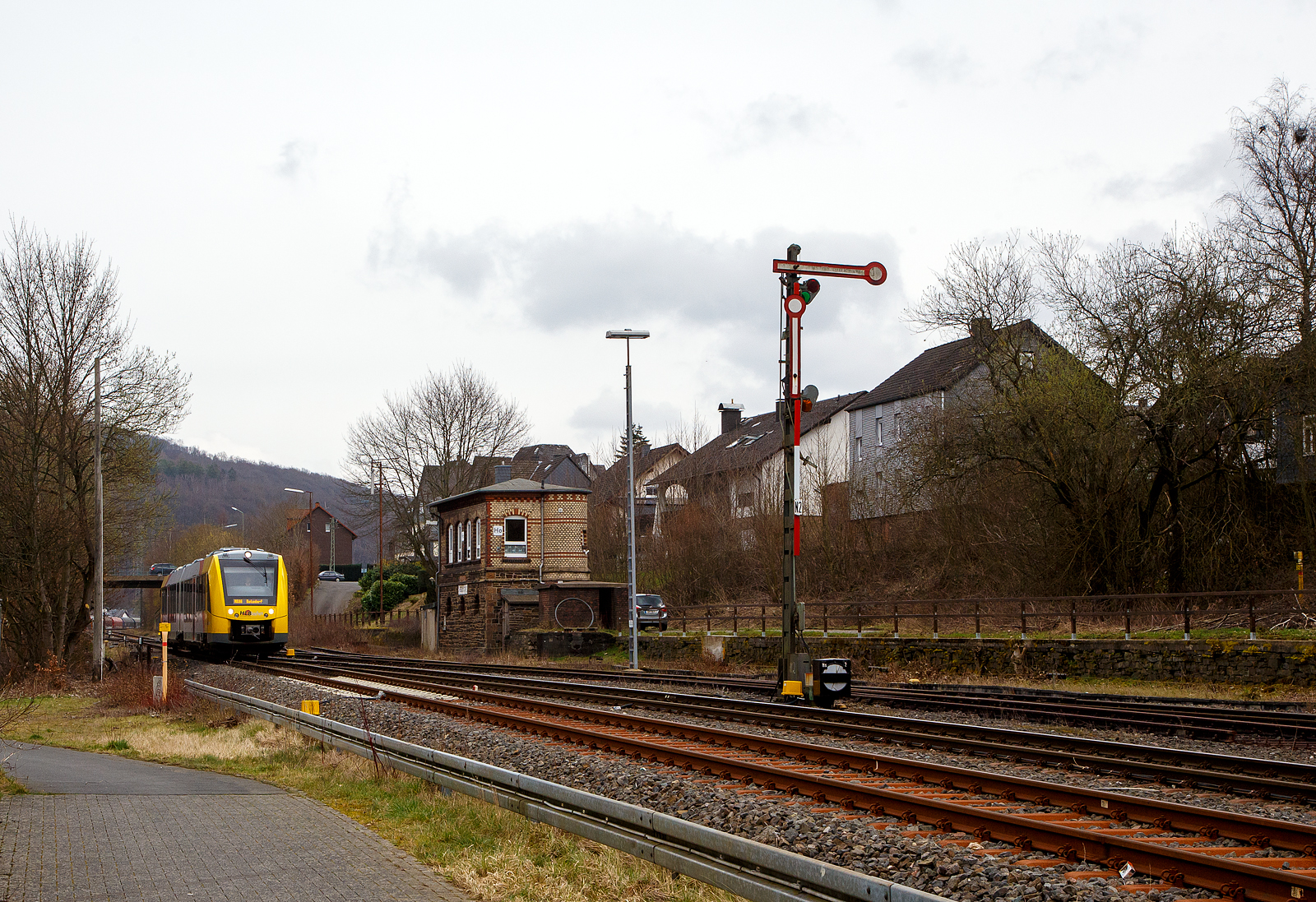 Nun fahren die Triebwagen der HLB RB 96 „Hellertalbahn“ auch endlich wieder den Bahnhof Herdorf an. Leider  ist aber dann in Herdorf am Hp Königstollen Schluss, ab dort gibt es dann von und nach Betzdorf (Sieg) SEV. Nach dem Hangrutsch (Felssturz) am 23. Dezember 2022 in Herdorf kurz hinter dem Hp  Königsstollen (bei km 88,4), ist der Abschnitt nach Betzdorf weiterhin bis mindestens bis zum kleinen Fahrplanwechsel am 11. Juni 2023, gesperrt. Aber diese ungewöhnliche Führung bis zum Hp  Königsstollen, über den Bahnhof Herdorf hinaus ist nötig, denn in den nächsten Tagen sollen die der Abriss und der Neubau der „Hellerbrücke“ der Hellerstraße (bei „Steinaus Eck“) beginnen und der SEV wäre so nur noch über Daaden oder Kirchen möglich.

Hier erreicht der VT 506 (95 80 1648 106-0 D-HEB / 95 80 1648 606-9 D-HEB), ein Alstom Coradia LINT 41 der neuen Generation / neue Kopfform, der HLB (Hessische Landesbahn GmbH) am 20.03.2023, als RB 96 „Hellertalbahn“ nach Betzdorf, bald den Bahnhof Herdorf.

Rechts das 1901 gebaute mechanische Weichenwärter Stellwerk Herdorf ost (Ho). Die beiden Stellwerke in Herdorf (Hf und Ho) sind in der Bauform Jüdel. Die Stellwerke der Bauform Jüdel (Max Jüdel & Co, Braunschweig) sind neben der Einheitsbauform am häufigsten in Deutschland anzutreffen. Viele andere Stellwerkshersteller haben Jüdel-Stellwerke in Lizenz gefertigt und dabei mehr oder weniger starke Änderungen vorgenommen.
