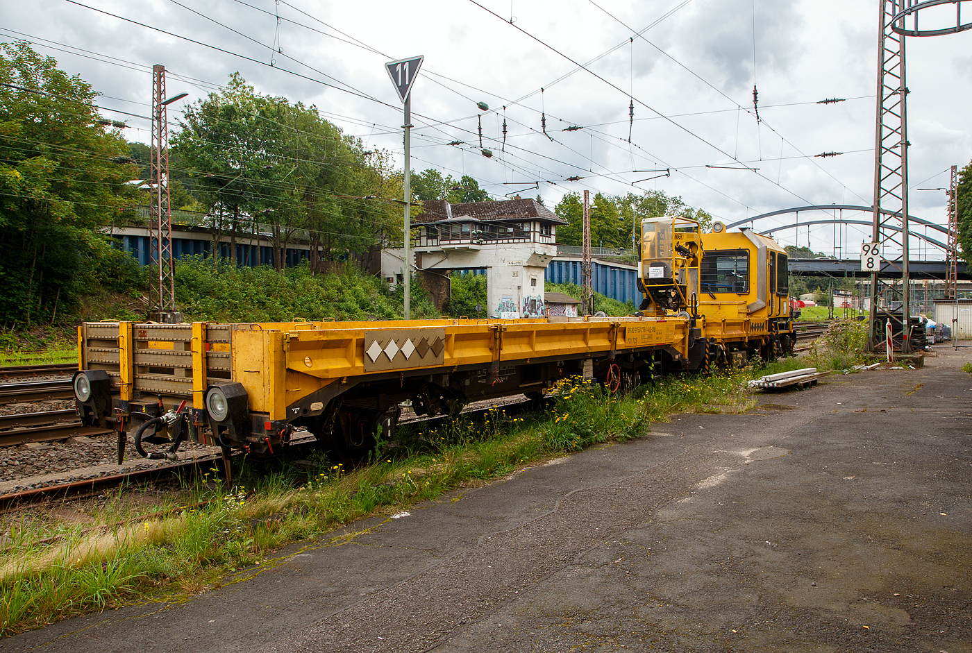 Nun haben die Anhänger H 27 (Anhänger zu den GAF 100) bei der DB eine eigene Baureihenbezeichnung und zwar BR 771. Auch die ganzen Gleiskraftwagenanhänger (H27 und die Kla´s) haben nun UIC-Nummer bekommen, sie werden eingereiht unter 99 80 9750 xxx.

DB 741 131 ein Gleisarbeitsfahrzeug GAF 100 R (Schweres Nebenfahrzeug Nr. 99 80 9420 037-0, ex 97 17 50 011 18-3), mit dem Gleiskraftwagenanhänger H27, Schweres Nebenfahrzeug Nr. D-DB 99 80 9750 276-4 (Anhängerfahrzeug BR 771 725) beide von der DB Netz AG, sind am 13.08.2023 in Kreuztal abgestellt. Da ich kein Fabrikschild finden konnte, kann ich keine ehemalige Nr. zuordnen.

Das GAF 100 R wurde 1996 von GBM (Gleisbaumechanik Brandenburg/H. GmbH) unter der Fabriknummer 52.1.124 gebaut, es hat die EBA Nummer EBA 96 P01 N023.

Das Gleisarbeitsfahrzeuge GAF 100 R ist ein Nebenfahrzeug das von der Firma GBM Gleisbaumechanik Brandenburg/H. GmbH gebaut wurde. Mit ihm können Personen (zur Mitfahrt sind 6 Personen zugelassen), Material und Ausrüstungen befördert werden können. Zudem hat es einen Palfinger PK 9001 Kran.

Der Antrieb des zweiachsigen Fahrzeuges erfolgt von einem 6 Zylinder, wassergekühlten MAM D 0826 LOH 07 Dieselmotor mit 169 kW (230 PS) Leistung über Lastschaltwendegetriebe auf die Radsatzgetriebe.

Technische Daten GAF:
Achsfolge: B
Länge über Puffer: 9.100 mm
Achsabstand: 4.800 mm
Treibraddurchmesser: 750 mm (neu)
Höchstgeschwindigkeit: 100 km/h
Eigengewicht: 16 t
Zul. Anhängelast: 40 t / (80 t mit Regelzugeinrichtung Hg 60 km/h)
Nutzlast : 5,0 t
Zur Mitfahrt zugel. Personen: 6
Der Antrieb des zweiachsigen Fahrzeuges erfolgt von einem 6 Zylinder, wassergekühlten MAN D 0826 LOH 07 Dieselmotor mit 169 kW (230 PS) Leistung über Lastschaltwendegetriebe auf die Radsatzgetriebe.

Der H 27 (Anhänger zu GAF 100) wurde von der GBM (Gleisbaumechanik Brandenburg/H. GmbH) gebaut.

Der GBM beschreibt dieses Fahrzeug wie folgt:
Der Anhänger H 27 wurde im Zusammenhang mit den Nebenfahrzeugen der Gleisbaumechanik Brandenburg entwickelt und ist in Ladeflächenhöhe, Kupplungsausführung sowie Energie - und Pneumatikanschlüssen diesen angepasst. Eine Anpassung an weitere Gerätesysteme ist nach Kundenwunsch möglich. Der Anhänger H 27 dient dem Transport von Baumaschinen, er ist aber auch gut für das Transportieren von Stückgut, Kleinteilen und Schienen geeignet. Der H 27 ist mit einem Paar einhängebarer Auffahrrampen ausgerüstet. Die Montage der Auffahrrampen kann mit 2 Personen realisiert werden. In seinen Abmessungen erfüllt er die Anforderungen nach EBO, Anlage 8. Der H 27 hat eine Spurweite von 1.435 mm. Der Fußboden des H 27 ist so dimensioniert, daß ein Befahren mit Gabelstaplern mit einer Radlast von 30 kN möglich ist. Zu den Fahrzeugenden hin ist der Fußboden geneigt ausgeführt. Dadurch verringert sich die Fußbodenhöhe von 1.000 mm über Schienenoberkante im mittleren Bereich auf 700 mm über Schienenoberkante. Durch angelegte Auffahrrampen ist es möglich, auf den H 27 mit Baumaschinen zu fahren.

Technische Daten Gleiskraftwagenanhänger:
Achsanzahl: 2
Achsabstand: 6.000 mm
Länge über Puffer: 9.750 mm
Höchstgeschwindigkeit: 100 km/h (vorgestellt 80 km/h)
Eigengewicht: 9,3 t
Zul. Anhängelast: 40 t
Nutzlast : 25,0 t
