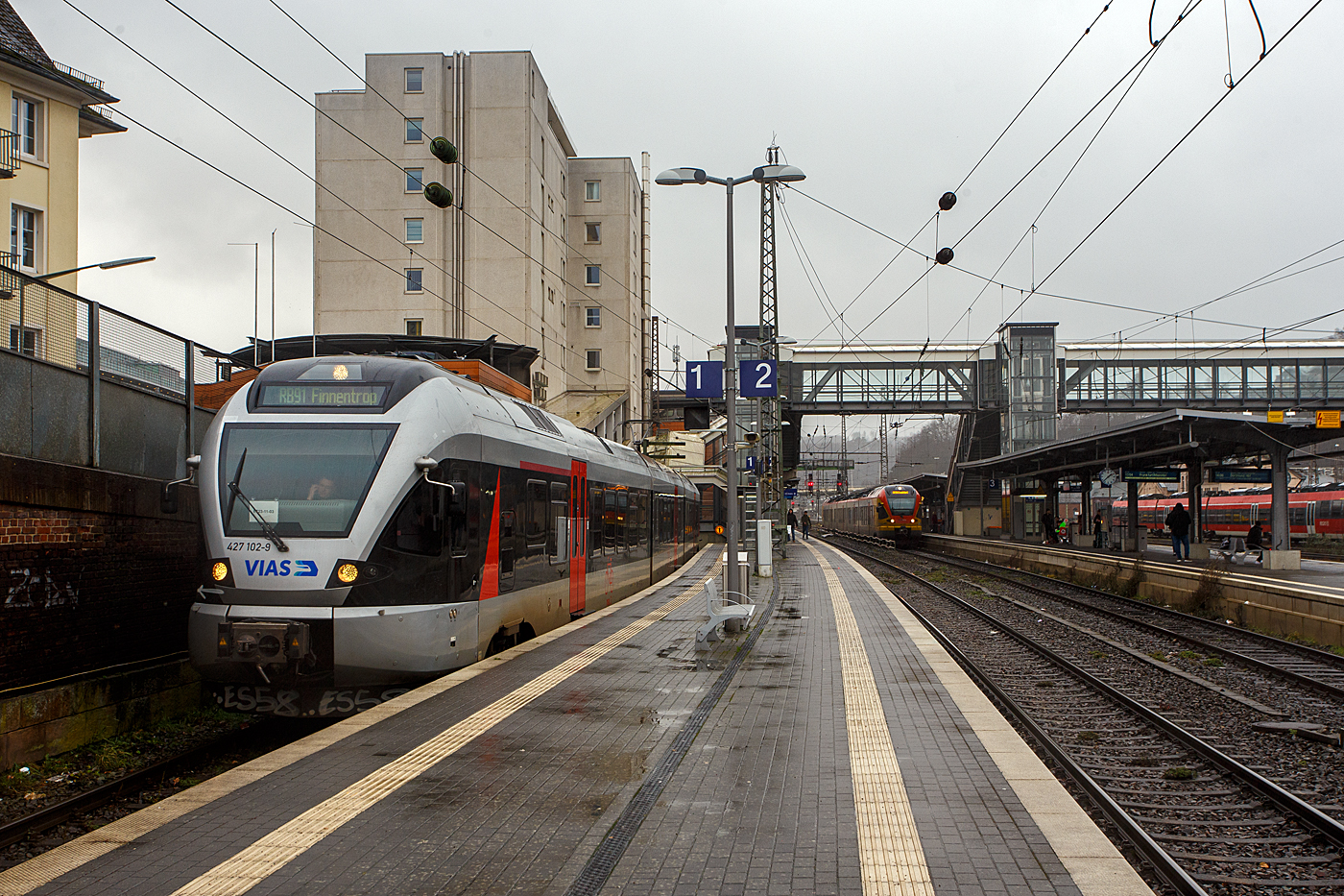 Nun mit VIAS-Logo.... 
Der (nun) VIAS Stadler FLIRT ET 23-11-03 (94 80 0427 102-9 D-VIASR / 94 80 0827 102-5 D-VIASR / 94 80 0427 602-8 D-VIASR), ex DB, ex Abellio Rail NRW ET 23 2103  Werdohl ,  ex ET 23 003, steht am 29 Dezember 2023, als RB 91  Ruhr-Sieg-Bahn  nach Finnentrop, auf Gleis 1 im Hauptbahnhof Siegen zur Abfahrt bereit.

Vom 9. Dezember 2007 bis zu seiner Insolvenz im Juli 2021 führte Abellio Rail NRW den Schienenpersonennahverkehr auf dem Ruhr-Sieg-Netz (RE 16 und RB 91) aus. Nach der Insolvenz übernahm zunächst per Direktvergabe wieder DB Regio mit dem Verkehr auf der Strecke bis Dezember 2023, seit dem Fahrplanwechsel im Dezember 2023 hat nun nach regulärer Vergabe schließlich die VIAS Rail GmbH den Schienenpersonennahverkehr (RE 16 / RB 91) bis Dezember 2034 übernommen.  VIAS Rail ist ein 100 %iges Tochterunternehmen der R.A.T.H.-Gruppe.

In Zusammenhang mit dem Neubau der Rahmedetalbrücke auf der A45 wurde die Nahverkehrsfreigabe der IC-Linie 34 zum 1. September 2022 auf den Abschnitt Dortmund–Iserlohn-Letmathe ausgeweitet, und seit dem 11. Dezember 2022 verkehrt in den Stunden ohne Intercity zwischen Siegen und Iserlohn-Letmathe anstelle der Linie RE 16 die neue Linie RE 34 (Dortmund-Siegerland-Express) betrieben durch die DB Regio, welche ebenfalls an Hagen vorbei nach Dortmund Hbf durchgebunden wird. So kann die Reisezeit zwischen Siegerland, Sauerland und Dortmund deutlich verkürzt werden. Eingesetzt werden neue Elektrotriebwagen des Typs Stadler Flirt 3 XL, aus aktuellen eigenen Beständen der S-Bahn Rhein-Ruhr.

Der FLIRT wurde 2007 von der Stadler Pankow GmbH in Berlin unter der Fabriknummer 34663 gebaut. Er wurde von Macquarie Rail (vormals CBRail) an die Abellio Rail NRW GmbH verleast bzw. vermietet. Im Jahr 2020 verkaufte Macquarie das Leasinggeschäft für Schienenfahrzeuge an die französischen Konkurrenten Akiem.