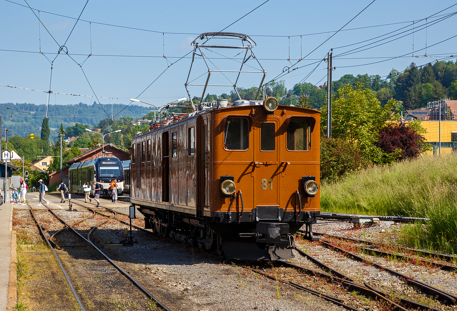 Pfingsten 2023 (Samstag 27. bis Montag 29. Mai 2023) fand bei der Museumsbahn Blonay–Chamby das Schweizer Dampffestival 2023 / Festival suisse de la Vapeur 2023 statt.

Die grandiose ehemalige Berninabahn RhB Ge 4/4 81 der Museumsbahn Blonay–Chamby, ex RhB Ge 4/4 181, ex BB Ge 4/4 81, ex BB Ge 6/6 81, am 27. Mai 2023 beim Umsetzen im Bahnhof Blonay, sie war führte den ersten Zuglauf des Tages. Eigentlich da die Lokomotive ein kleines Gepäckabteil und sechs Achsen besitzt, müsste sie als Triebwagen De 4/6 bzw. Fe 4/6 (ex Fe 6/8) klassifiziert sein, aber die Berninabahn und später die RhB wollten sie als Lokomotive und nicht als Triebwagen klassifizieren.

Die Ge 4/4 81war ursprünglich eine sechsachsige Elektrolokomotive (Ge 6/6) der ehemaligen Berninabahn (BB), welche 1943 in der Rhätischen Bahn (RhB) aufging. Als Einzelstück wurde sie von der Schweizerischen Lokomotivfabrik in Winterthur (SLM) mit elektrischer Ausrüstung von Brown, Boveri & Cie. (BBC) hergestellt und 1916 abgeliefert. Als schmalspurige Elektrolokomotive mit sechs angetriebenen Achsen erhielt sie die Bauartbezeichnung Ge 6/6 und die Betriebsnummer 81, bereits 1929 wurde sie bei der SLM in Winterthur zur BB Ge 4/4 81 umgebaut.

Die damals rasche Verkehrszunahme verlangte nach einer eigenen Lokomotive für den schweren Verkehr. Mit einem Gewicht von 45 Tonnen, verteilt auf ursprünglich sechs Antriebsachsen und zwei kleine Achsen für den Hilfsrahmen des Bremsgestells mit der elektromagnetischen Schienenbremse, und vier Fahrmotoren galt sie damals als stärkste meterspurige Lokomotive Europas. Je zwei Motoren waren in einem Drehgestellrahmen fest verschraubt, die Kraftübertragung erfolgte von der Motorwelle zunächst auf eine Vorgelegewelle. Die beiden Vorgelegewellen und die mittlere Triebachse jedes Drehgestells waren mit einem Dreiecksrahmen verbunden. Die äußeren Achsen wurden mittels Kuppelstangen angetrieben. Diese Anordnung bewährte sich nicht. Es ist überliefert, dass eine Dreieckskuppelstange in voller Fahrt nach Bruch der Kurbeln durch das Dach geschleudert wurde.

Umbau zur Ge 4/4 81:
1929 wurde die Lok von der Achsfolge C’C’ auf die Achsfolge B’B’, beim Hersteller SLM in Winterthur, umgebaut. Durch den Umbau sollte die Leistung der Lok für geplante Express-Züge erhöht werden. Die mittlere Achse jedes Drehgestells wurde durch eine Blindwelle ersetzt. Die Kraftübertragung von den Motoren her erfolgt neu durch ein Getriebe. Die Triebachsen werden durch Schlitzkuppelstangen angetrieben. Beim Umbau wurde die Lok auf die bevorstehende Spannungserhöhung von 750 Volt auf 1000 Volt vorbereitet. Dadurch konnte die Leistung von 960 PS auf 1040 PS gesteigert werden. Die zulässige Höchstgeschwindigkeit wurde von 50 km/h auf 45 km/h gesenkt.

Als Besonderheit besitzt die Lokomotive einen mit zwei Achsen ausgerüsteten Hilfsrahmen für die aus der Fahrleitung gespeiste elektromagnetische Schienenbremse. Infolge dieses Hilfsrahmens hätte die Lokomotive korrekterweise die Achsfolge B’2’B’, ursprünglich C’2’C’. Die Bauartbezeichnung einschließlich des Bremsgestells würde Ge 4/6 (beziehungsweise früher Ge 6/8) lauten, unter Berücksichtigung des Gepäckabteils De 4/6 (früher Fe 4/6 beziehungsweise Fe 6/8).

Bei der Rh B - Rhätischen Bahn erhielt die Lokomotive 1961 die Betriebsnummer 181. 1970 wurde sie ausgemustert und kam zur Museumsbahn Blonay–Chamby (BC), wo sie anfänglich regelmäßig eingesetzt wurde. Ab 1990 verhinderte ein Schaden an der elektrischen Ausrüstung die weitere Nutzung. Erst 2008 konnte die Lokomotive mit Hilfe eines Sponsors so weit aufgearbeitet werden, dass sie seither wieder eingesetzt werden kann.

Am 23. August 2021 wurde die Lok auf der Straße nach Landquart überführt, damit sie Anfang Oktober bei Sonderfahrten auf der Berninabahn eingesetzt werden konnte. Nachdem die BC und der Club 1889, der in Samedan historische Fahrzeuge der RhB erhält, die Lokomotive für den Einsatz am Bernina angepasst haben, zog die Lokomotive im Februar 2022 aus eigener Kraft einen Extrazug von St. Moritz zur Station Alp Grüm (2.091 m.ü.M.). In Folge wurde die Maschine für weitere Sonderfahrten auf ihrer ehemaligen Stammstrecke eingesetzt und kehrte erst im Oktober 2022 wieder zur Museumsbahn BC zurück.

TECHNISCHE DATEN  der Ge 4/4 81 (Ge 4/6):
Betriebsnummern: BB 81 / RhB 81 / RhB 181
Gebaute Anzahl: 1 (Eizelstück)
Hersteller mecha. Teil: Schweizerischen Lokomotivfabrik in Winterthur (SLM) 
Elektrischer Ausrüstung:  Brown, Boveri & Cie., Münchenstein (BBC)
Inbetriebsetzung: 1916  (1929 Umbau von der Ge 6/6 zur Ge 4/4)
Spurweite: 1.000 mm (Meterspur)
Achsanordnung: B’B’, ursprünglich C’C’
Länge über Puffer: 13.900 mm
Höhe über S.o.K.: 3.840 mm (abgesenkter Stromabnehmer) / 6.250 mm gehoben 
Drehzapfenabstand: 7.560 mm
Achsabstand im Drehgestell: 2.100 mm (Achse/Motor/Achse 1.150 / 950 mm)
Treibraddurchmesser: 855 mm (neu)
Achsabstand im Bremswagen: 1.360 mm
Laufraddurchmesser im Bremsgestell: 280 mm (neu)
Dienstgewicht: 46,0 t
Höchstgeschwindigkeit: 45km/h (anfänglich 50 km/h)
Dauerleistung: 708 kW (4 x 177 kW) / 962 PS (urspr. 455 kW / 620 PS) 
Anfahrzugkraft: 14.500 kg
Getriebeübersetzung: 1:4.28
Stromsystem: 900 V  DC (Gleichstrom)
Stromübertragung: 2 Stromabnehmer
Anzahl der Fahrmotoren: 4
Antrieb: elektrisch
Bremse: Vakuumbremse, elektrische Widerstandsbremse, Magnetschienenbremsen