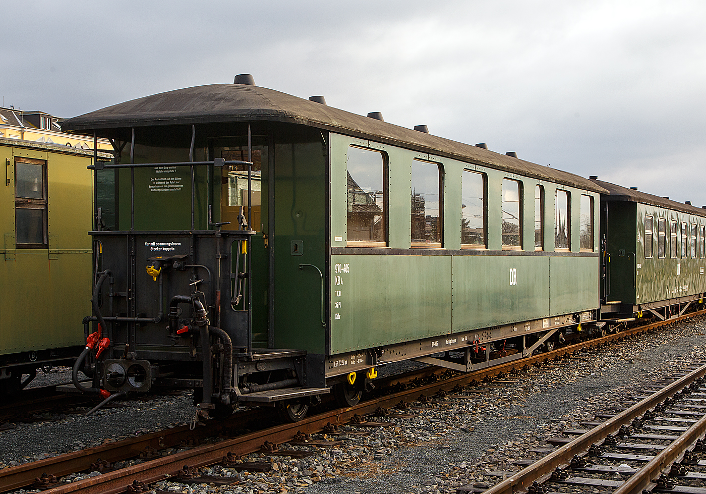 SDG Lößnitzgrundbahn: Der schöne vierachsige Schmalspurig modernisierter Altbau Personenwagen 970-405 mit offenen Plattformen und großen Fenstern, der Gattung KB4 (ex sächsischen Gattung 720), der Lößnitzgrundbahn (zur SDG - Sächsische Dampfeisenbahngesellschaft mbH), ex DR 970-405, am 07.12.2022 in Radebeul Ost.

Der Wagen wurde 1922 von Busch in Bautzen gebaut. Die Wagennummer waren vermutlich K.Sächs.Sts.E.B. (1922-1927) 618 K; DRG/DRB/DR (1927-1949); K 339; DR (1949-1951) 7.0339; DR/DB/BVO/SDG (1951bis heute) 970-405. Durch die großen Fenster bot sich ein guter Ausblick auf die Landschaft, wodurch diese Wagen bei den Fahrgästen sehr beliebt waren (sog.  Großfenstriger ). 

TECHNISCHE DATEN:
Gattung: sächsische 720 / KB4 (Altbau, modernisiert)
Hersteller: Busch Werk Bautzen (später Linke-Hofmann-Busch)
Baujahr: 1922
Spurweite: 750 mm
Achsanzahl: 4
Länge über Kupplung: 13.500 mm
Drehzapfenabstand: 8.100 mm
Achsabstand im Drehgestell: 1.300 mm
Eigengewicht: 11.300 kg
Höchstgeschwindigkeit.: 
Sitzplätze: 36 (3. Klasse / Holzbänke)
Besonderheiten: 1 Abort (offene Toilette)
Kupplungstyp: Scharfenbergkupplung
Bremse: Saugluftbremse

