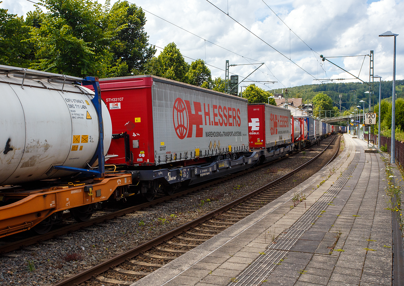 Sechsachsiger Gelenk-Taschenwagen (Doppeltaschenwagen Typ T3000e in Gelenkbauart) der Gattung Sdggmrss (33 52 495 6 242-2 BG-WASCO) der Trade Trans Group (eingestellt durch die WASCOSA AG in Bulgarien) am 14 Juli 2024 im Zugverband bei der Zugdurchfahrt in Kirchen an der Sieg. Hier beladen mit 2 Sattelzuganhänger. 

Diese Güterwagen sind zum Transport von kranmanipulierbaren Sattelaufliegern und genormten Wechselbehältern / Containern an allen europäischen Eisenbahnstrecken mit Normalspurweite bestimmt, auch bekannt als intermodaler Verkehr.

Die Trade Trans Group hat 100 neue dieser Doppeltaschenwagen vom Typ Sdggmrss von der bulgarischen Firma Kolowag Eood hergestellen lassen und befinden sind im Besitz der Trade Trans Invest, a.s. Bratislava. der Kunden im europäischen Raum bestimmt.

Die Trade Trans Group besteht aus 50 unabhängig geführten Speditions- und Logistikunternehmen, die in zwölf Ländern vertreten sind. Damit ist die Gruppe ein zentraler Anbieter einer Vielzahl von Logistikdienstleistungen entlang der Hauptverkehrsachsen in Europa. Die strategischen Standorte der Unternehmen ermöglichen es der Trade Trans Group, Straßengüterverkehr und intermodale Netzwerke miteinander zu verbinden.

TECHNISCHE DATEN:
Spurweite: 1.435 mm
Länge über Puffer: 34.200 mm
Drehzapfenabstand: 2 x 14.200 mm
Achsabstand im Drehgestellen: 1.800 mm
Laufraddurchmesser: 920 mm (neu) / 860 mm (abgenutzt)
Drehgestelle: 1x Y25Ls(s)i1f und 2 x Y25Lssi1-K
Eigengewicht: 35.700 kg
Max. Zuladung bei Lastgrenze S: 99,3 t (ab Streckenklasse D)
Max. Zuladung bei Lastgrenze SS: 84,3 t (ab Streckenklasse C)
Max. Geschwindigkeit: 100 km/h (Lastgrenze SS und leer 120 km/h)
Kleinster befahrbarer Gleisbogen: R 75 m
Max. Radsatzlast S/SS: 22,5 t / 20 t
Ladelänge: 2 x 16.100 mm
Höhe der Ladeebene (bei Container) über S.O.: 1.155 mm
Intern. Verwendungsfähigkeit: TEN GE
