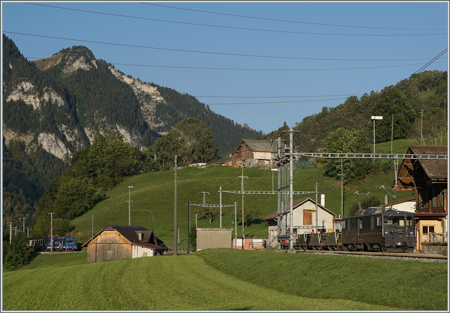 Seit die MOB GDe 4/4 nicht mehr im planmässigen Reisezugverkehr zum Einsatz kommen, sind Bilder dieser Loks nicht mehr so einfach zu bekommen. Um so mehr freute ich mich,  als ich  die GDe 4/4 6002 in Rossinière mit einem kurzen Güterzug entdeckte. Die Lok schob die Wagen und war in Richtung Montreux unterwegs. Der Grund des gut viertelsündigen Aufenthaltes ist ganz links im Bild wage zu erkennen: Der Güterzug musste die Kreuzung mit dem von der MOB Ge 4/4 8001 geführten Goldenpass Express GPX 4064, unterwegs von Montreux nach Interlaken Ost, abwarten. 

29. September 2023