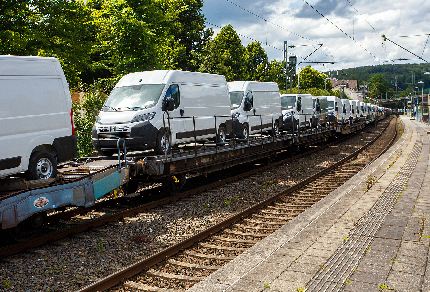 Vierachsige (2 x 2 achsige) Flachwageneinheit mit geradem Fu�boden und Radvorlegern, sowie mit Absturzsicherung, der TRANSWAGGON AB Schweden, der Gattung Laads (TWA NLA1), 24 74 4313 815-5 S-TWASE, beladen mit 4 Nutzfahrzeuge (FIAT - Kastenwagen), 14 Juli 2024 im Zugverband bei einer Zugdurchfahrt im Bahnhof Kirchen (Sieg).

TECHNISCHE DATEN:
Gattung: Laads (NLA1)
Spurweite: 1.435 mm
Anzahl der Achsen: 4 (2 x 2)
L�nge �ber Puffer : 27.000 mm
Ladel�nge : 25.760 mm 
Ladebreite : 2.512 mm 
Fu�bodenh�he �ber SOK: 1.200 mm
Anzahl der Radvorleger: 16
H�chstgeschwindigkeit: 100 km/h  / 120 km/h (leer)
Eigengewicht: 26.500 kg
Nutzlast: 53,5  t ab Streckenklasse C
Achsabst�nde: 9.000 mm / 4.140 mm / 9.000 mm 
Kleinster befahrb. Gleisbogenhalbmesser: 75 m
Bremse: 2 x KE-GP-A (LL)
Intern. Verwendungsf�higkeit: RIV