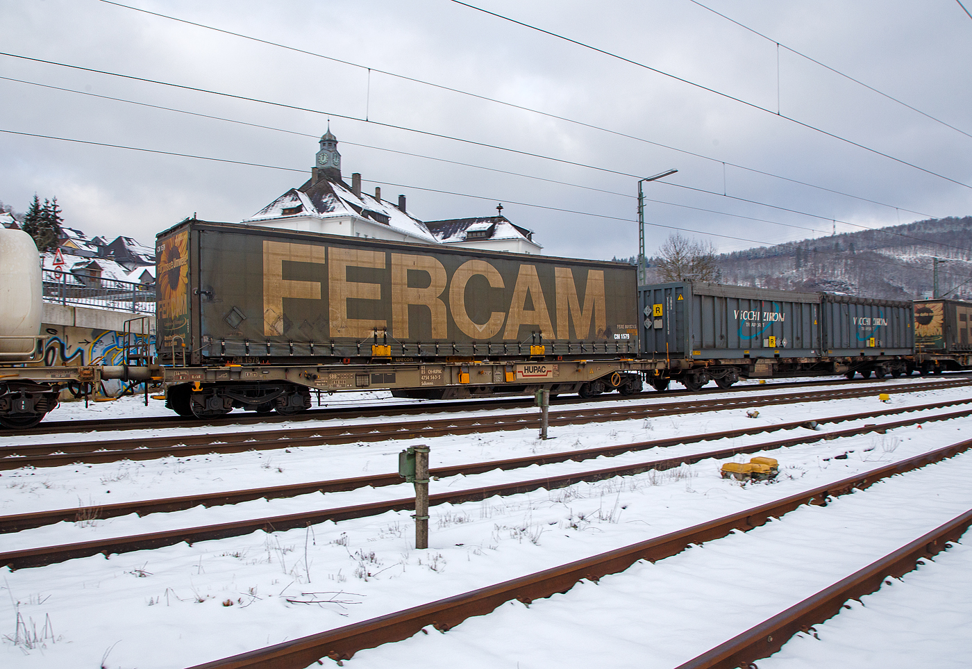 Vierachsiger Drehgestell-Taschenwagen für den Transport von Sattelaufliegern und Container 83 85 4754 563-5 CH-HUPAC der Gattung Sdkmms der HUPAC Intermodal SA, im Zugverband am 21.01.2023 bei der Zugdurchfahrt in Niederschelden (Sieg), hier beladen mit einer Sattelauflieger-Wechselbrücke. 

Der Wagen wurden 1980 von Waggonfabrik Talbot in Aachen gebaut.

TECHNISCHE DATEN:
Spurweite: 1.435 mm
Länge über Puffer: 16.440 mm
Drehzapfenabstand: 11.200 mm
Achsabstand im Drehgestellen: 1.800 mm
Max Ladelänge: 1 Sattelanhänger  (14.400 mm f. Container und Wechselbehälter)
Eigengewicht: ca. 16.000 kg 
Max. Zuladung bei Lastgrenze S: 44,0  t (ab Streckenklasse A)
Höchstgeschwindigkeit: 100 km/h (beladen) / 120 km/h (leer)
Bremse: O-GP-A (K)
Bremssohle: Jurid 816M (K-Sohle)
Kleinster befahrbarer Gleisbogen: R 75 m
Intern. Verwendungsfähigkeit: Privatwagen

Die Bedeutung der Gattungs- und Kennbuchstaben (hier Sdkmms):
S - Drehgestell-Flachwagen in Sonderbauart
d - für den Transport von Straßenfahrzeugen eingerichtet
k - mit vier Radsätzen höchste Lastgrenze unter 40 t
mm - mit vier Radsätzen Ladelänge unter 15 m
s - Höchstgeschwindigkeit 100 km/h (beladen)