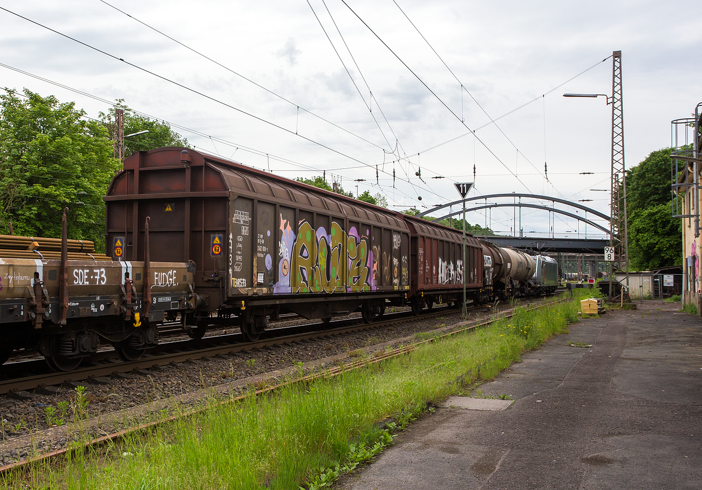 Zweiachsiger großräumiger Schiebewandwagen (Gedeckter Wagen in Sonderbauart), 21 80 2462 610-1 D-DB der Gattung Hbbillns 305 der DB Cargo AG, am 21 Mai 2024 im Zugverband bei einer Zugdurchfahrt in Kreuztal. 

Der Hbbillns 305 ist ein Güterwagen mit zwei Radsätzen, zweiteiligen Aluminium-Schiebewänden und sechs verriegelbaren Trennwänden. Dieser großräumige gedeckte Wagen ist mit Schiebewänden ausgerüstet, die von einer Person bewegt werden können. Im geöffneten Zustand ist der Zugang zur gesamten Ladefläche von beiden Seiten möglich. 

Die Be- und Entladen mit Gabelstaplern ist damit sowohl von einer Rampe als auch von ebener Erde möglich. Dieser Wagen ist für eine schonende Beförderung hochempfindlicher Güter verschiedener Art mit der Transportschutzeinrichtung  Verriegelbare Trennwände  ausgestattet. Bei Transportschutzeinrichtungen kann der Wagenraum in einzelne Kammern unterteilt werden. Ladefläche und Laderaum verringern sich um den Anteil der eingebauten Transportschutzeinrichtung. Die verriegelbaren Trennwände rasten in Lochleisten (alle 45 mm) in Fußboden und am Obergurt des Wagens ein. Die 6 Trennwände in Stahl-Holz-Verbundbauweise sind 2.400 mm hoch und 2.650 mm breit, sie sind alle 45 mm verriegelbar. Belastbarkeit durch das Ladegut (Anlagefläche mindestens 1.600 mm breit x 700 mm hoch), gegen 1 Trennwand beträgt maximal 5 t bzw. gegen 2 unmittelbar nebeneinander verriegelte Trennwände maximal 7 t.

Das Untergestell ist als Schweißkonstruktion hergestellt und besteht aus zwei durchlaufenden Außenlangträgern und Querträgern, die die Langträger verbinden und auf denen die Kräfte aus Fußboden und Nutzlast über Fußbodenträger abgesetzt werden. Der Fußboden besteht aus 45 mm dicken Kiefernbohlen und ist zum Befahren mit Gabelstaplern für eine Belastung von max. 2,2 t pro Vorderrad zugelassen.

TECHNISCHE DATEN:
Gattung/Bauart: Hbbillns 305
Spurweite: 1.435 mm (Normalspur)
Länge über Puffer : 15.500 mm
Achsabstand: 8.000 mm
Laufraddurchmesser: 920 mm (neu)
Eigengewicht: 16.460 kg
Ladelänge: 14.200 mm
Ladefläche: 41,3 m²
Laderaum: 105,0 m³
Max. Zuladung: 28,5 (ab Streckenklasse D) / DB CM 25,5 z
Max. Geschwindigkeit: 100 km/h (beladen) / 120 km/h (leer)
Kleinster befahrbarer Gleisbogen: R 50 m
Intern. Verwendungsfähigkeit: RIV