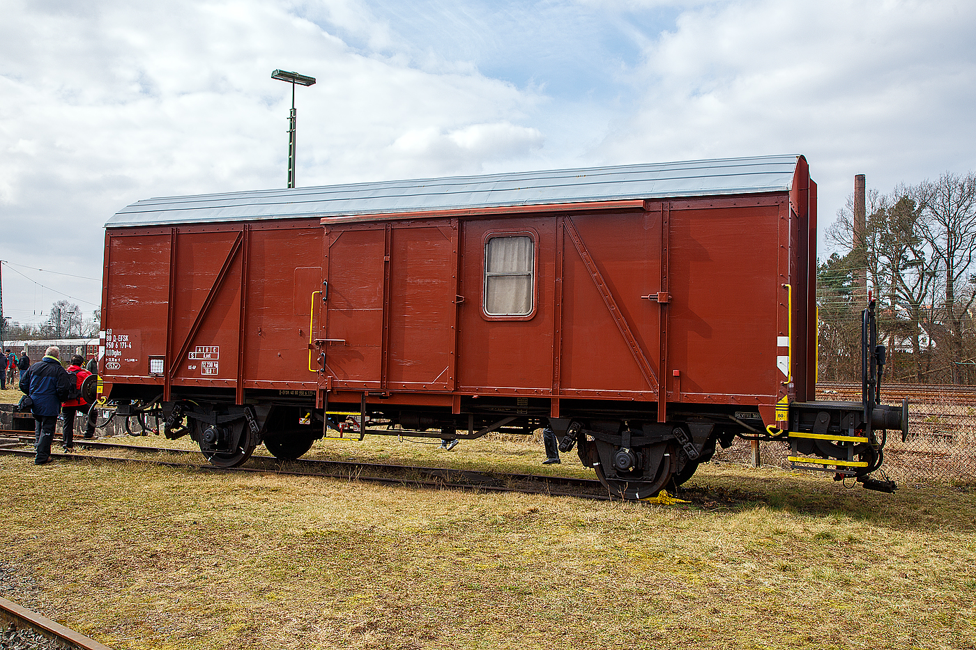 Zweiachsiger Güterzuggepäckwagen mit Bremserbühne 40 80 950 6 171-4 D-EFSK der Gattung (U) Dghs (ex Pwghs54), der Eisenbahnfreunde Treysa e.V., ausgestellt am 24.03.2018 beim Lokschuppenfest, zum 30-jährigen Jubiläum der Eisenbahnfreunde in Treysa (Ortsteil der Stadt Schwalmstadt).

Güterzuggepäckwagen bzw. Güterzugbegleitwagen fehlten nach dem Krieg, hauptsächlich solche, die für höhere Geschwindigkeiten geeignet waren. Daher startete die DB ein Umbauprogramm auf Basis des Gms 54. Diese Wagen entstanden teilweise aus brauchbaren Teilen der G10, wurden aber in weiten Teilen neu gebaut. Die Pwgs 54 waren ursprünglich mit Gleitachslagern ausgestattet, wurden aber gegen Ende der 1960er Jahre immer mehr mit Rollenachslagern Bauart 22 ausgestattet. Der Aufbau der Pwgs 54 erfolgte analog zum Gms 54 mit Leimholzplatten, die Wagen hatten einseitig eine Bremserbühne, über diese gelangte man in den Innenraum. Der Pwghs 54 erhielt ein Zugführerabteil mit Zweiplatz-Klappsitz, Ablagepult und zwei Notsitzen sowie ein WC. Passende Einbauteile standen aus dem 3yg-Umbauprogramm zur Verfügung. Der recht große Laderaum hat eine Schiebetür von 1.800 mm Breite. Zusätzlich wurden eine Dampfheizung und eine 24V Beleuchtung eingebaut, die mit einem Kabel an die Turbobeleuchtung der Zuglokomotive angeschlossen werden konnte. Der Einsatz der Güterzuggepäckwagen endete in den 1970er Jahren.

TECHNISCHE DATEN:
Spurweite: 1.435 mm (Normalspur)
Achsanzahl: 2
Länge über Puffer: 11.100 mm
Achsabstand: 5.840 mm
Ladefläche: 15,2 m²
Eigengewicht: 12.230 kg
Max. Zuladung: 6,0 t (ab Streckenklasse A)
Höchstgeschwindigkeit: 100 km/h
Bremse: KE-GP
Intern. Verwendungsfähigkeit: nein (nur DB)