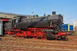 Die DB 82 008 (ex DB 082 008-4) am 23.04.2011 im Südwestfälische Eisenbahnmuseum in Siegen.

Die Lok wurde 1951 bei Krupp in Essen unter der Fabriknummer 2884 gebaut und als 82 008 an die DB geliefert, 1968 wurde sie in DB 082 008-4 umgezeichnet. Die Ausmusterung bei der DB erfolgte am 18.04.1972.

Bis 2014 stand sie (als Leihgabe) im Südwestfälische Eisenbahnmuseum in Siegen, seit April 2014 ist sie nun im DB Museum Koblenz-Lützel zu sehen.

Zum Einheitslok-Typenprogramm der Deutschen Bundesbahn (DB) gehörte auch die fünfachsige Güterzugtenderlokomotive der Baureihe 82. Sie war für den Rangier- und Streckendienst vorgesehen und sollte die fünffach gekuppelten Länderbahnbauarten ablösen, aber auch die durch das komplexe Laufwerk Schad anfällige Einheitslokomotiven der DR-Baureihe 87.

Die Baureihe 82 wurde als erste Neubaulokgattung der DB zwischen 1950 und 1951 von den Unternehmen Krupp und Henschel und in einem weiteren Baulos 1955 von der Maschinenfabrik Esslingen gefertigt.

Bei der Konstruktion versuchte man eine gleichermaßen gut für den Rangier- wie Streckendienst geeignete Maschine zu schaffen. Nach dem bisherigen Stand der Technik widersprachen die für beide Dienste maßgeblichen Konstruktionskonzepte einer gleichwertigen Eignung für beide Dienstbereiche. Dieser Widerspruch sollte durch einen Kessel moderner Bauart und die besondere Laufwerkskonstruktion beseitigt werden.

Um ohne die für eine reine Rangierlokomotive überflüssigen Laufradsätze die für den Streckendienst auch bei höheren Geschwindigkeiten notwendigen sicheren, ruhigen und gleisschonenden Laufeigenschaften zu erhalten, entschied man sich nach Vorversuchen mit einer umgerüsteten preußischen T 16 dazu, das jeweils äußere Kuppelradsatzpaar zu einem Beugniot-Lenkgestell zu vereinigen. Bisherige laufradsatzlose Fünfkuppler-Tenderlokomotiven mit Radsatzanordnung nach Gölsdorf wie etwa die T 16 hatten sich nämlich als für höhere Geschwindigkeiten über rund 40 km/h aufgrund des ausgesprochen unruhigen Laufes als wenig geeignet erwiesen.

Mit den Beugniot-Lenkgestellen waren die Maschinen zugleich ohne die aufwendige Laufwerkstechnik der Baureihe 87 in der Lage enge Gleisbögen (R=100 m), wie z.B. auf der Hamburger Hafenbahn, einwandfrei zu durchfahren.

Bei der Auslegung des Kessels entschied man sich für einen geschweißten Kessel mit großer Strahlungsheizfläche, aber ohne Verbrennungskammer, damit dieser sowohl unter den unregelmäßigen Leistungsanforderungen im Rangierdienst als auch bei Spitzen- und hohen Dauerleistungen im Streckendienst standfest blieb.

Bei der Dimensionierung der Zylinder, die bei einer Rangierlokomotive wegen der aufzubringenden großen Kräfte mit kleinem Durchmesser, bei einer Streckenlokomotive hingegen zur Ausnutzung der Dampfdehnung großvolumig auszulegen gewesen wären, entschied man sich für einen Kompromiss. Dieser führte allerdings, wie vom Bauartdezernenten Friedrich Witte vorhergesagt, zu einem erhöhten Brennstoffverbrauch. Im Rangierdienst schwankte der Mehrverbrauch zur T 16 um 10 bis 19 %, im Streckendienst sogar um 30 %.

Beim Laufwerk wurde nur der dritte Treibradsatz, fest im Rahmen gelagert. Die beiden jeweils außen liegenden Kuppelradsatzpaare verband man mit Beugniot-Hebeln zu jeweils einem Lenkgestell. Die Endradsätze waren um insgesamt 52 mm seitlich verschiebbar, der zweite bzw. vierte Kuppelradsatz noch um insgesamt 36 mm.

Die Lokomotiven der Baureihe 82 bewältigten eine Wagenzugmasse von 800 t in der Ebene mit 70 km/h. Auf Steigungen von 10 Promille konnten noch 400 t mit 40 km/h befördert werden.

Belegt sind Einsätze vor allem auf den Rangierbahnhöfen in Bremen und Hamm sowie den Hafenbahnen von Emden und Hamburg. Im Streckendienst konnten die 82er auf den Steilrampen Siegerland und Westerwald und im Schwarzwald auf der Murgtalbahn beobachtet werden.

Neben einem hohen Schmierölverbrauch bemängelte der Betriebsdienst an der Baureihe 82 vor allem außer den problematischen Heißdampfreglern und schlecht funktionierenden Strahlpumpen einen raschen, durch Verschmutzung bedingten, Verschleiß der Lenkgestelle.

Die Ausmusterung begann bereits 1966, Auslauf-Bw war Koblenz-Mosel, wo die letzte Maschine dieses Typs 1972 abgestellt wurde. Die Baureihe war damit früher aus dem Dienst geschieden als die Baureihe 94, welche sie ja ersetzen sollte.
Fast alle Lokomotiven dieser Baureihe wurden nach Einsatzende verschrottet, lediglich die hier gezeigte 82 008 stellte man 1974 als Denkmal am Bahnhof Lingen (Ems) auf, sie gelangte so in den Bestand des DB Museums. Nach Stationen in Neumünster (2003-2010) und Siegen (2010-2014) befindet sie sich nunmehr im DB Museum Koblenz.


Technische Daten der Baureihe 82:
Gebaute Anzahl: 41 (DB 82 001 - 041)
1435 mm (Normalspur)
Achsformel / Bauart:  E h2t
Gattung:  Gt 55.18
Länge über Puffer:  14.060 mm
Höhe:  4.450 mm
Gesamtachsstand:  6.600 mm
Leergewicht:  69,7 t
Dienstgewicht:  87  t
Achslast:17,4 t
Höchstgeschwindigkeit:  70 km/h (vorwärts / rückwärts)         
Leistung:  1.290 PSi (949 kW)
Treibraddurchmesser:  1.400 mm
Steuerungsart:  Heusinger
Zylinderanzahl:  2
Zylinderdurchmesser : 600 mm
Kolbenhub:  660 mm
Kesselüberdruck:  14 bar
Anzahl der Heizrohre:  113
Anzahl der Rauchrohre:  38
Heizrohrlänge:        4.000 mm
Rostfläche:   2,39 m2
Überhitzerfläche:  51,90 m2
Verdampfungsheizfläche:   122,21 m2
Kohlenvorrat:   4 t
Wasservorrat:  11 m3
Seit 1960 ist die 82 008 mit einer Riggenbach-Gegendruckbremse ausgerüstet.

Quellen: wikipedia, eisenbahn-museumsfahrzeuge.de