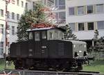 E 69 04 in M�nchen auf einem Sockel vor der Oberpostdirektion, aus einem ge�ffneten Oberlicht einer fahrenden Strassenbahn fotografiert, am 26.05.1979 (Diascan).
