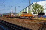 Die DEW 7 (Lok 7 der Deutschen Edelstahlwerke GmbH), zuvor Edelstahlwerke Südwestfalen, rangiert am 05 September 2023 mit vierachsigen Drehgestellflachwagen am Haken, vom Anschlussgleis zurück aufs Werksgelände in Siegen-Geisweid.

Die Lok ist eine MaK G 1203 BB und wurde1986 unter der Fabriknummer 1000808 in Kiel gebaut und an die Krupp Stahl AG, Werk Siegen-Geisweid, geliefert.

Die Lokomotive MaK G 1203 BB ist eine dieselhydraulische Lokomotive, die von der Maschinenbau Kiel (MaK) gebaut wurde, die Achsfolge ist B’B’. Sie erreicht eine maximale Geschwindigkeit von bis zu 70 km/h. Eingebaut wurden Motoren von MTU (745 kW) und für sechs Exporte nach Gabun mit amerikanischen Cummins-Motoren (761 kW). Die MaK G 1203 BB wurde zwischen 1982 und 1991 in 25 Exemplaren gebaut. Sie gingen an 14 verschiedene Eisenbahnbetreiber in Deutschland. Eine Lok ging nach Schweden und sechs nach Gabun.

Im Deutschen Fahrzeugeinstellungsregister wurde für diese Bauart die Baureihennummer 98 80 0273 vergeben.

Ab 1978 wurden im dritten Typenprogramm zwei verschiedene vierachsige Loks angeboten. Die leistungsschwächere erhielt die Bezeichnung G 1201 BB. Sie setzte sich nicht so recht durch und wurde nur einmal gebaut. Als ab 1981 die leistungsstärkeren Motoren der Reihe 396 zur Verfügung standen, änderte man die Typenbezeichnung in G 1203 BB. Äußerlich kann man diese beiden Typen an ihrem Lüftungsgitter an der Vorderseite der langen Haube erkennen.

TECHNISCHE DATEN:
Spurweite: 1.435 mm (Normalspur)
Achsfolge: B´B´
Länge über Puffer 12.500 mm
Drehzapfenabstand: 5.800 mm
Achsabstand im Drehgestell: 2.400 mm
Treibraddurchmesser: 1.000 mm (neu)
größte Breite: 3.100 mm
größte Höhe über Schienenoberkante: 4.220 mm
kleinster befahrbarer Gleisbogen: 60 m
Dienstgewicht: 88 t
Kraftstoffvorrat: 2.500 l
Motor : MTU, Typ 8V 396 TC 13, ein V8-Zylinder-Dieselmotor mit Abgasturbolader und Ladeluftkühlung,
Leistung: 745 kW (1.012 PS)
Drehzahl: 1.800 U/min
Getriebe: Voith, Typ L4r4zU2

Die Deutschen Edelstahlwerke sind die deutsche Produktionsgesellschaft der Swiss Steel Group mit Hauptsitz in Luzern, Schweiz, einem der weltweit führenden Produzenten von Spezialstahl-Langprodukten. Dank des ausschließlichen Einsatzes von Stahlschrott in Elektrolichtbogenöfen zählt die Gruppe zu den europaweit relevantesten Unternehmen in der Kreislaufwirtschaft und ist im Bereich nachhaltig produziertem Stahl – Green Steel – unter den Marktführern. Swiss Steel Group verfügt über eigene Produktions- und Distributionsgesellschaften in über 30 Ländern. 

Die Eckdaten der Geisweider Eisenwerke (heute Teil der Deutschen Edelstahlwerke) :
1845: Gründung des Stahlwerks durch J.H. Dresler als Eisen- und Walzwerk
1872: Errichtung von Hochofen 1
1879: Umbennung in  Geisweider Eisenwerke AG 
1889: Inbetriebnahme des ersten Siemens-Martin-Stahlwerks
1902: Errichtung von Hochofen 2 (mit der noch existierenden Gießhalle)
Ende 1. Weltkrieg: Stillegung beider Öfen (mehrjährige Pause wegen Weltwirtschaftskriese und Quotenvorgaben für Stahlunternehmen)
1920: Aufkauf durch Thyssen und Klöckner, anschließend Teil der Vereinigten Stahlwerke AG, dem zweitgrößten Stahlproduzenten weltweit
1938: Hochofen 2 wird renoviert und modernisiert und geht wieder in Betrieb, Stillstand am Ende des 2. Weltkriegs
1948: der verbliebene Hochofen geht wieder in Betrieb
1951: auf Annordnung der Alliierten Hohen Kommission erfolgte die Zerschlagung der VESTAG und Geisweid Teil der Stahlwerke Südwestfalen AG im Verbund mit dem Stahlwerk Hagen (vorm. Eicken), den Stahlwerken Brünninghaus und der FriedrichThomée AG aus Werdohl
1972: 100 Jahre Hochofenbetrieb in Geisweid, 70 Jahre Hochofen 2 
1974: Übernahme durch Krupp (Krupp Edelstahlprofile)
1978: Installierung eines 140 t Elektrolichtbogenofen (der größte in Deutschland)
1979/1981: Stillegung/Abbruch des Hochofens 2, es war der letzte Siegerländer Hochofen
2004: das Geisweider Werk geht an die Deutschen Edelstahlwerke in der Schmolz&Bickenbach-Gruppe zur Swiss Steel Group gehörend, wieder unter dem Namen Deutsche Edelstahlwerke Specialty Steel. 

Das Stahlwerk in Siegen-Geisweid betreibt einen 140 t Elektrolichtbogenofen und eine 6-adrige Stranggießanlage, um Edelstahl-Knüppel für das eigene Stabstahlwalzwerk und die Drahtstraße in Hagen herzustellen. Der Edelstahl wird aus Schrott hergestellt. Von einstmals rund  7.000 Arbeitsplätzen sind heute noch rund 1.100 verblieben.
