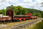 Vierachsiger Drehgestellflachwagen ohne Rungen, mit festen hohen Stirnwänden, 31 80 3531 008-1, der Gattung Rloos-w, der DB Cargo AG, am 11 Juli 2025 im Zugverband bei einer Zugdurchfahrt durch