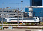 Eine Trenitalia E.403 (91 83 2402 0xx-8 I-TI), in weiß-grau-roter IC-Lackierung, ist am 16.07.2022 beim Bahnhof Napoli Centrale abgestellt. Die Aufnahme konnte ich aus einem ausfahrenden IC machen.

Die Trenitalia / FS E.403 baut auf die FS E.402B auf, war auch ursprünglich als E.402 C vorgesehen, haben aber einen anderen elektrischen und elektronischen Teil als die E.402B. 24 Loks wurden von AnsaldoBreda zwischen 2005 bis 2008 gebaut. 

Anfang der 2000er Jahre entwickelte Trenitalia Pläne zur Ausweitung seines Güterverkehrs auf das europäische Festland, insbesondere auf dem Korridor Italien-Österreich-Deutschland sowie der Schweiz. 
Eine neue Lokomotive musste konzipiert werden, damit die Pläne Wirklichkeit werden konnten, und wurde ursprünglich als E.402C bezeichnet. Es war eine Weiterentwicklung der E.402B-Lokomotive mit zusätzlicher Ausrüstung für den Betrieb in diesen Ländern und wesentlich anderen Hembot-Drehgestellen. Die Loks waren für den Einsatz vor schnellen Güterzügen vorgesehen und hatten ursprünglich auch vier Einholm-Stromabnehmer für Oberleitungen-Spannungen von 1,5 kV DC, 3 kV DC, 15 kV ~ 16 2/3 Hz und 25 kV ~ 50 Hz. 

Das Programm erlitt große Schläge: Als AnsaldoBreda diese Lokomotivenserie exklusiv für Trenitalia auf einer nicht standardmäßigen Plattform (im Gegensatz zu den Lokomotiven der TRAXX und EuroSprinter/Vectron, die sich Standardkomponenten teilen) baute, explodierten die Kosten. Die Lokomotive wurde verkleinert, indem die 1,5-kV- und 15-kV-Teile sowie die französischen, deutschen und österreichischen Sicherheitssysteme entfernt wurden. Stattdessen übernahm Trenitalia 51% der Anteile an TXLogistik und beantragte die Zulassung seiner E.412- Lokomotiven in Österreich und Deutschland. Die (eingeschränkte) österreichische und deutsche Zulassung wurde 2006 erteilt, wobei TXLogistik Lokführer die Züge in Österreich und Deutschland fahren.


Die Lokomotive sollte nun in schnellen Güterzügen eingesetzt werden, die teilweise auf den neuen Hochgeschwindigkeitsstrecken verkehren. Bis Februar 2010 verkehrte jedoch noch kein Güterzug auf den HS-Strecken und die E.403 waren noch nicht im Linienverkehr. In den ersten Monaten des Jahres 2010 beschloss die Trenitalia, diese Lokomotiven der Passagierabteilung zuzuordnen und erst 2012 erfolgte die endgültige Zulassung der Loks.

Aus der Mehrsystemlokomotive wurde eine rein italienische Zweisystemlokomotive für 3 kV Gleich- und 25 kV 50 Hz~ Wechselstrom. Die Baureihe E.403 kann so unter 3.000 V Gleichstromspannung, dem hauptsächlichen italienischen Bahnnetz, aber auch auf den italienischen Schnellfahrstrecken mit 25 kV, 50 Hz Wechselstrom fahren. Fernerhin kann sie unter 1.500 V Gleichstrom betrieben werden, dann hat sie aber nur die halbe Leistung. Die Lokomotiven verfügen über eine elektrische regenerative und rheostatische Bremse, sowie eine mechanische Scheibenbremse mit zwei Scheiben pro Achse. Die Loks haben auch ein variables Übersetzungsverhältnis von 45/71 oder 33/92. 

TECHNISCHE DATEN:
Hersteller: AnsaldoBreda
Gebaute Anzahl: 24 
Baujahre: 2005-2008 (Ineinssetzung 2012)
Spurweite:  1435 mm (Normalspur)
Achsformel: Bo'Bo'
Länge: 19.900 mm
Drehzapfenabstand: 10.450 mm
Achsabstand im Drehgestell: 2.750 mm
Treibraddurchmesser:  1.110 mm (neu)
Dienstgewicht: 86 t
Höchstgeschwindigkeit: 180 km/h
Übersetzungsverhältnis: variabel 45/71 oder 33/92
Stundenleistung: 6.000 kW
Dauerleistung: 5.600 kW (7.500 PS)
Anfahrzugkraft: 315 kN
Dauerzugkraft: 265 kN
Stromsysteme: 3000 V DC und 25 kV - 50 Hz AC 