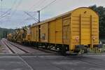 Swietelsky Schotterbettreinigungsmaschine RM 80-92 (9981 9414 001-3) schiebt die Schottersammelwagen im Schneckentempo über den Bahnübergang in Enscherange.