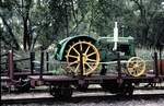 Schmalspur Flachwagen, beladen mit einem Traktor John Deere bei der Östra Södermanlands Järnväg in Mariefred am 07.08.1994.