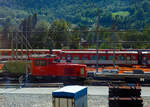 Die MGB HGm 2/2  703 der Matterhorn Gotthard Bahn steht am 08 September 2021 im MGB Depot Brig-Glis (Glisergrund), aufgenommen aus einem Zug.

Die Stadler HGm 2/2 ist eine zweiachsige dieselelektrische Rangierlok mit gemischten Zahnrad- und Adhäsionsantrieb, die in gleicher Grundbauform, mit unterschiedlicher Antriebsart von Stadler Rail für Bahnen in der Schweiz, Spanien und Österreich gebaut wurde. So sehen die MGB Tea 2/2, Gm 2/2 und HGm 2/2 sich sehr ähnlich.

2017 bestellt die MGB eine neue Kleinlok-Familie:
Stadler entwickelte, baute und liefert sieben Lokomotiven an die Matterhorn Gotthard Bahn (MGBahn). Der Auftrag umfasste zwei elektrische Rangierloks vom Typ Tea 2/2 (801 und 802) und eine dieselelektrische Rangierlok mit reinem Adhäsionsantrieb vom Typ Gm 2/2 (811), sowie vier dieselelektrische Lokomotiven mit Zahnrad- und Adhäsionsantrieb vom Typ HGm 2/2 (701 bis 704) für den Einsatz bei Infrastrukturarbeiten. Das Bestellvolumen belief sich auf über 23 Millionen Schweizer Franken. Die Neubeschaffung führt zu einer Homogenisierung der MGB-Flotte und einer erheblichen Reduktion der Lärm- und Abgasemissionen.

Das technische Konzept der neuen Kleinlok-Familie bietet der MGBahn einen optimalen Betrieb der Fahrzeuge. Alle drei Lok-Typen verfügen über die gleiche Kabine, die gleiche Traktions- und Leittechnikstruktur, die gleichen Steuerungselemente und die gleiche Bedienphilosophie. Die Subsysteme in den Apparateschränken sind benutzer- und unterhaltsfreundlich eingebaut, teilweise auf Auszugsschienen und mit Zugangs-Klappen.

Die sieben Meterspur-Lokomotiven sind allesamt 8.37 m lang und 2.65 m breit. Die Höhe variiert je nach Antriebskonzept. Das einheitliche Fahrzeugkonzept ergibt trotz drei Loktypen viele Gleichteile. Die Loks verfügen über eine leistungsfähige Traktionsausrüstung von ABB mit einem im Vorbau angeordneten Doppelblock-Stromrichter. Die Elektro-Rangierloks besitzen als Besonderheiten einen zusätzlichen Batterieantrieb für nicht elektrifizierte Gleise, eine Funkfernsteuerung sowie drei aus der Kabine bedienbare Kupplungssysteme für die diversen Typen von zu rangierenden Fahrzeugen. Die Loks mit dieselelektrischem Antrieb verfügen über einen umweltfreundlichen Dieselmotor von Mercedes-Benz mit Abgasstufe Euro-lll-B. Die Zahnradloks der Infrastruktur können auch die Streckenabschnitte in der Schöllenenbahn 	(181 ‰) und auf der Gornergrat Bahn (200 ‰) befahren.

Die neuen elektrischen Rangierlokomotiven ersetzen bestehende, in die Jahre gekommene Diesellokomotiven und sorgen so für umweltfreundlichen Rangierbetrieb. Bei den Zahnrad-Infraloks handelt es sich um Neubeschaffungen/Ergänzung. Sie werden einerseits den höheren Bedarf der MGBahn bei den laufenden Modernisierungsarbeiten an der Infrastruktur abdecken, aber auch die bisher bei Infrastrukturbauten eingesetzten Triebfahrzeuge entlasten, die eigentlich hauptsächlich für den Personenverkehr bestimmt sind.

Die Loks wurden 2018 bis 2019 von Stadler gebaut, diese ist Baujahr 2019. Stadler ist der weltweit führende Hersteller von Zahnradbahnen.

TECHNISCHE DATEN:
Spurweite: 1.000 mm
Achsfolge: Bo'zz
Hersteller: Stadler Rail AG
Länge über Puffer: 8.370 mm
Achsabstand: 
Breite: 2.650 mm
Dienstgewicht: 26,5 t
Höchstgeschwindigkeit : 60 km/h (Adhäsion)  / 35 km/h (Zahnrad)
Leistung am Rad (bzw. Zahnrad): 400 kW
Zahnstangensystem : Systems Abt (mit zwei Lamellen)
Max. Streckenneigung: 200 ‰)

