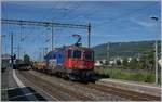Die SBB Re 421 377-3 fährt mit einem Güterzug durch die Haltestelle Biel Mett, rechts im Bild ist der Rangierbahnhof zu sehen.