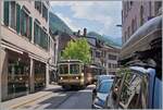 Der letzte noch in der braunen Farbgebung gehaltene AL Zug, bestehend aus dem AL Bt 351  Aigle  und dem AL BDeh 4/4 302  Leysin  ist in der Altstadt von Aigle auf der Fahrt zum Bahnhof von Aigle.