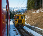 Bei Cadera überholt unser RhB Regionalzug nach St. Moritz am 20 Februar 2017 den RhB Tm 2/2 98 mit dem zweiachsigen Offenen Niederbordwagen Xa-t 931 13, er muss uns am Ausweichgleis abwarten.  

Der Traktor wurde 1999 von Windhoff unter der Fabriknummer 160807/2 gebaut. Der offenen Niederbordwagen, ex Xk-w 911 03, ex Kk-w 7316, ist Baujahr 1911. 

Das neue fünfstellige Nummernsystem der RhB:
9 = Dienstfahrzeuge 
3 = Fahrbahnbau 
1 = Transportwagen 
Die vierte und fünfte Stelle sind dann die Wagennummern.

TECHNISCHE DATEN Tm 2/2:
Spurweite: 1.000 mm
Achsfolge: B
Länge über Puffer: 8.790 mm
Achsabstand: 4.750 mm
Breite: 2.700 mm
Leergewicht: 22 t
Ladegewicht: 2 t
Höchstgeschwindigkeit: 60 km/h (60 km/h Schleppfahrt)
Motorbauart: 6-Zylinder-Dieselmotor
Motorleistung:  336 kW 
Anfahrzugkraft: 78 kN 
Stundenzugkraft: 30 kN bei 25 km/h
Leistungsübertragung: hydraulisch
